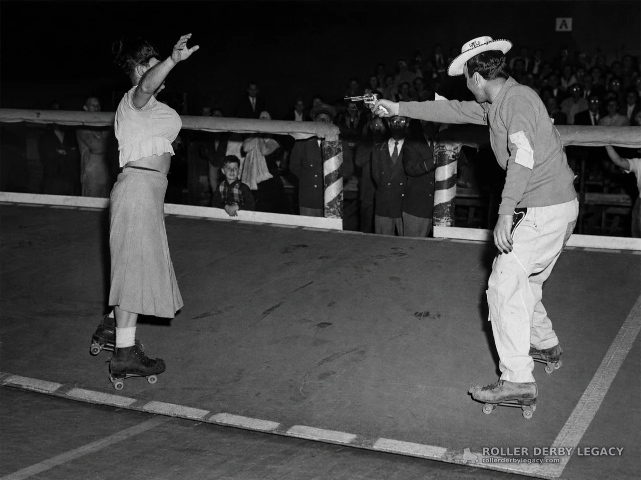 Cowboy-Hatted Skater Points Revolver at Woman on Rink