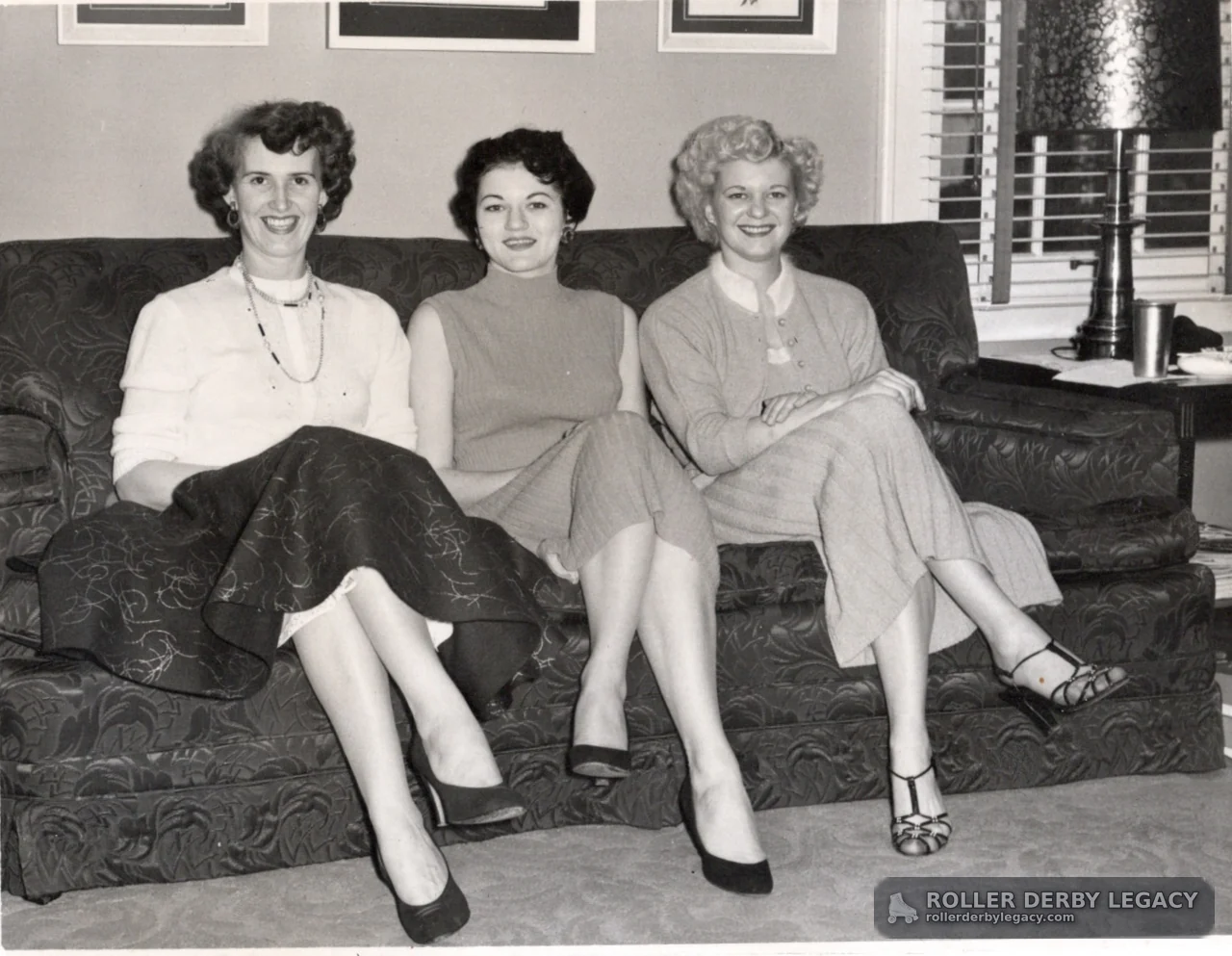 Three Women Seated on a Patterned Sofa