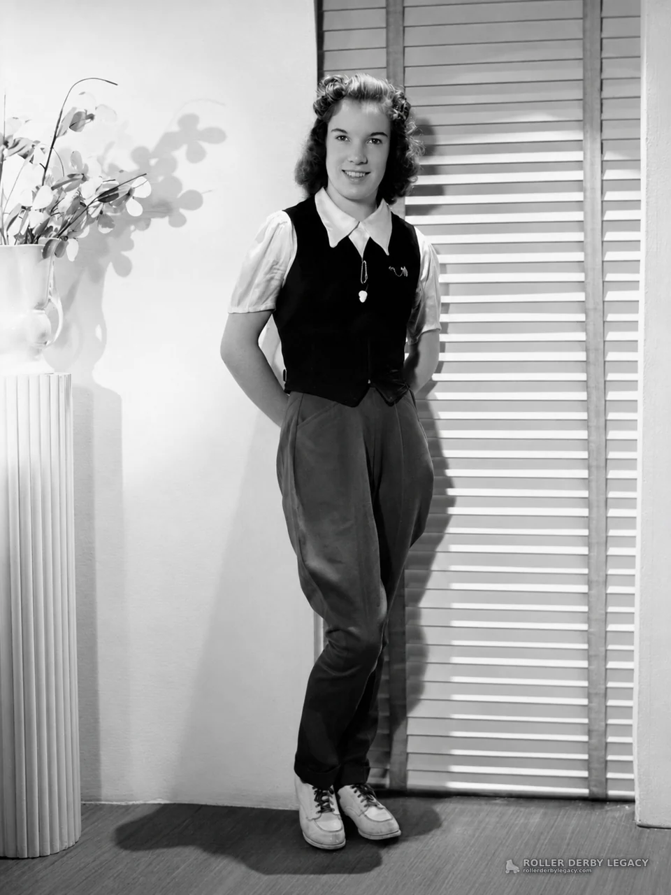Studio Portrait of Young Woman Beside Louvered Shutters