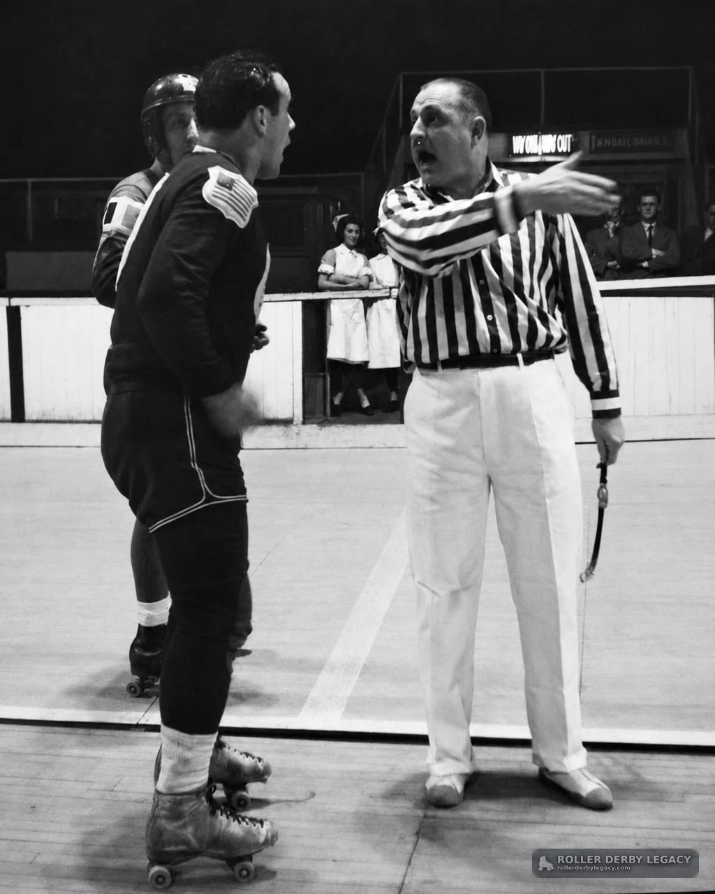 Referee Directs Skaters on an Indoor Roller Derby Rink
