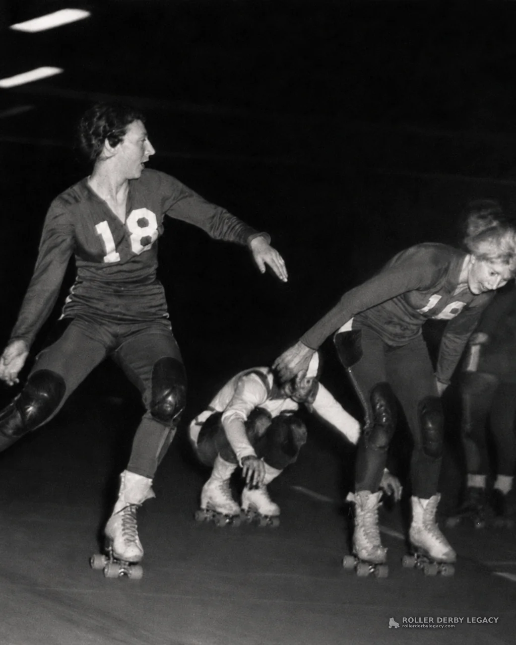 Roller Derby Skaters in Number 18 Jerseys on Indoor Track