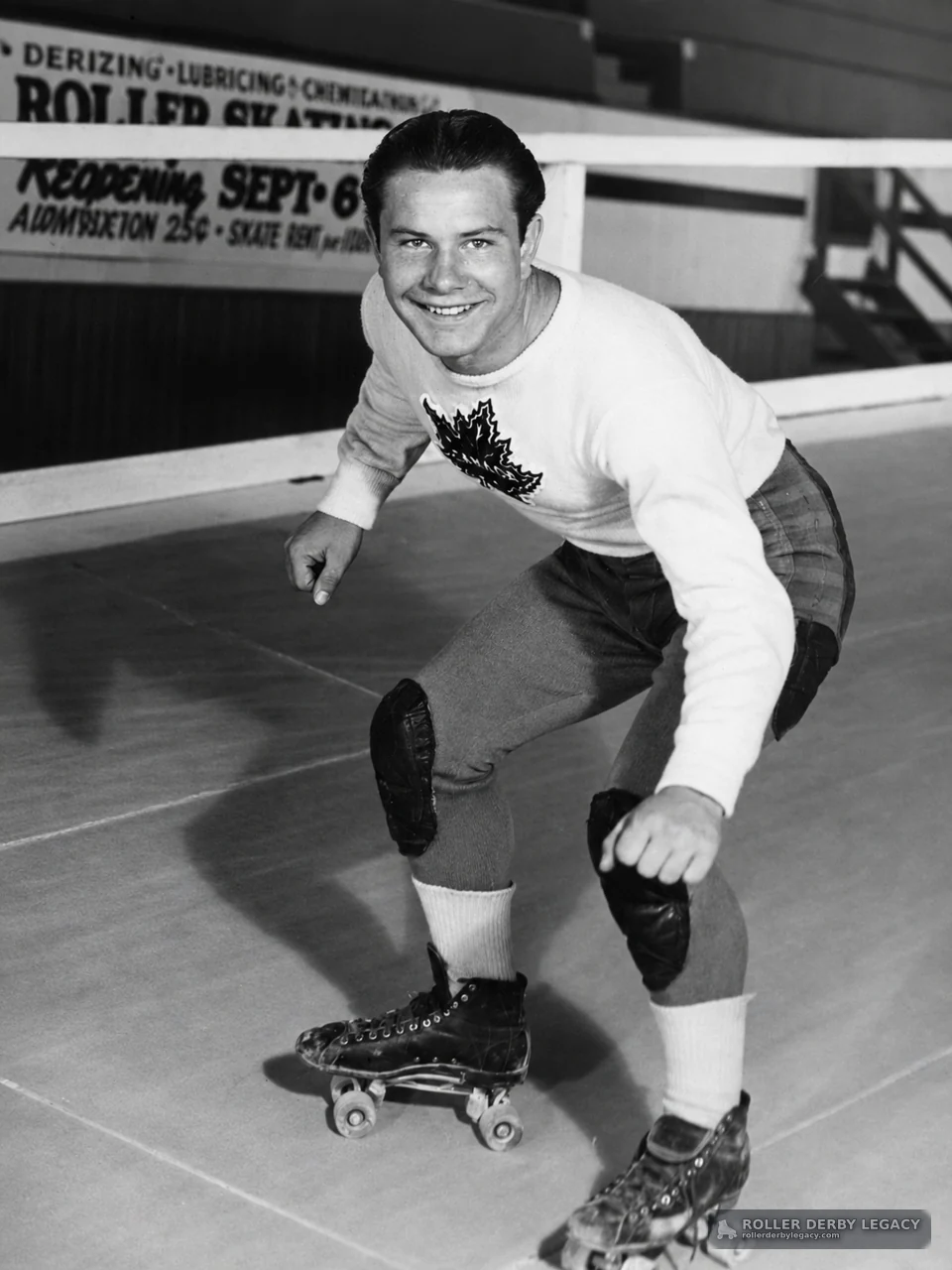 Smiling Skater in Low Stance at Indoor Rink