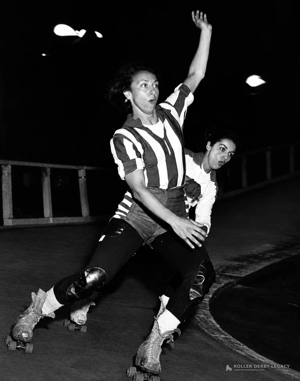 Two Roller Skaters in Close Action on an Indoor Track