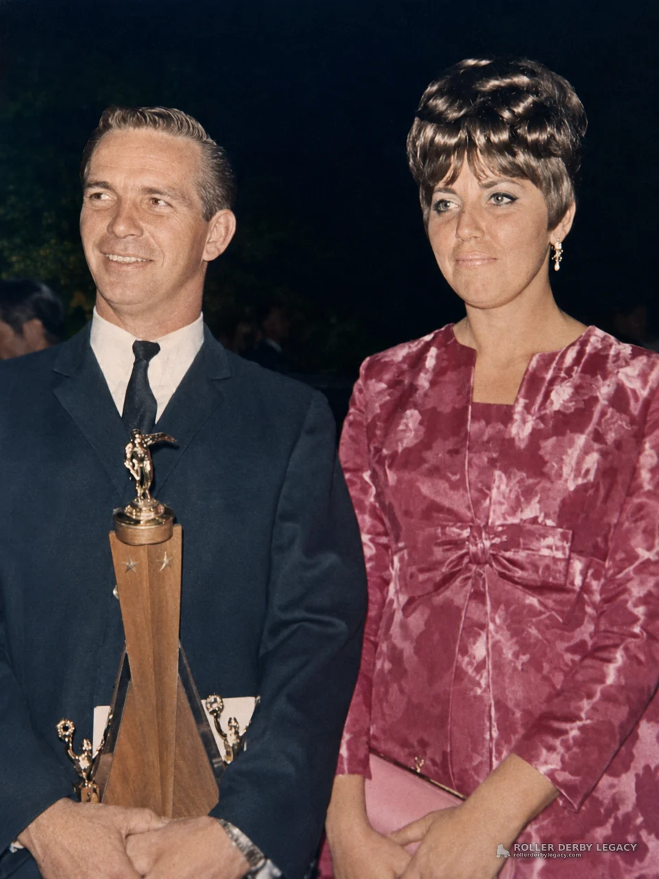 Couple Posing with Trophy at Award Ceremony