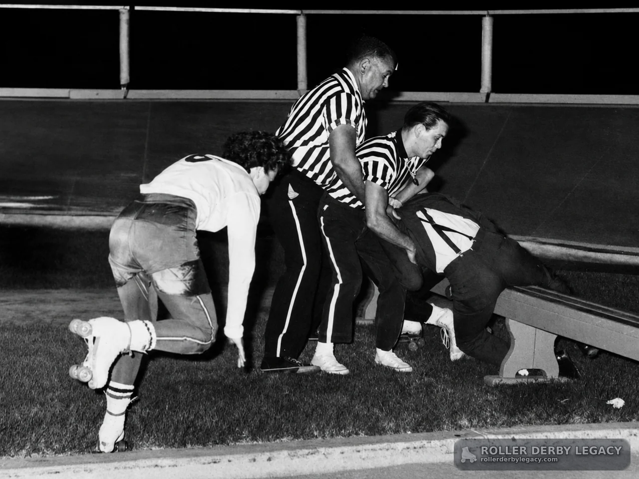 Officials Restrain Skater Beside Roller Derby Track