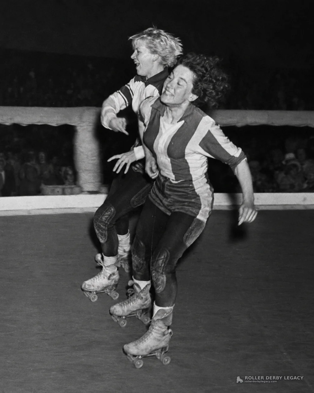 Two Skaters in Striped Uniforms on an Indoor Rink