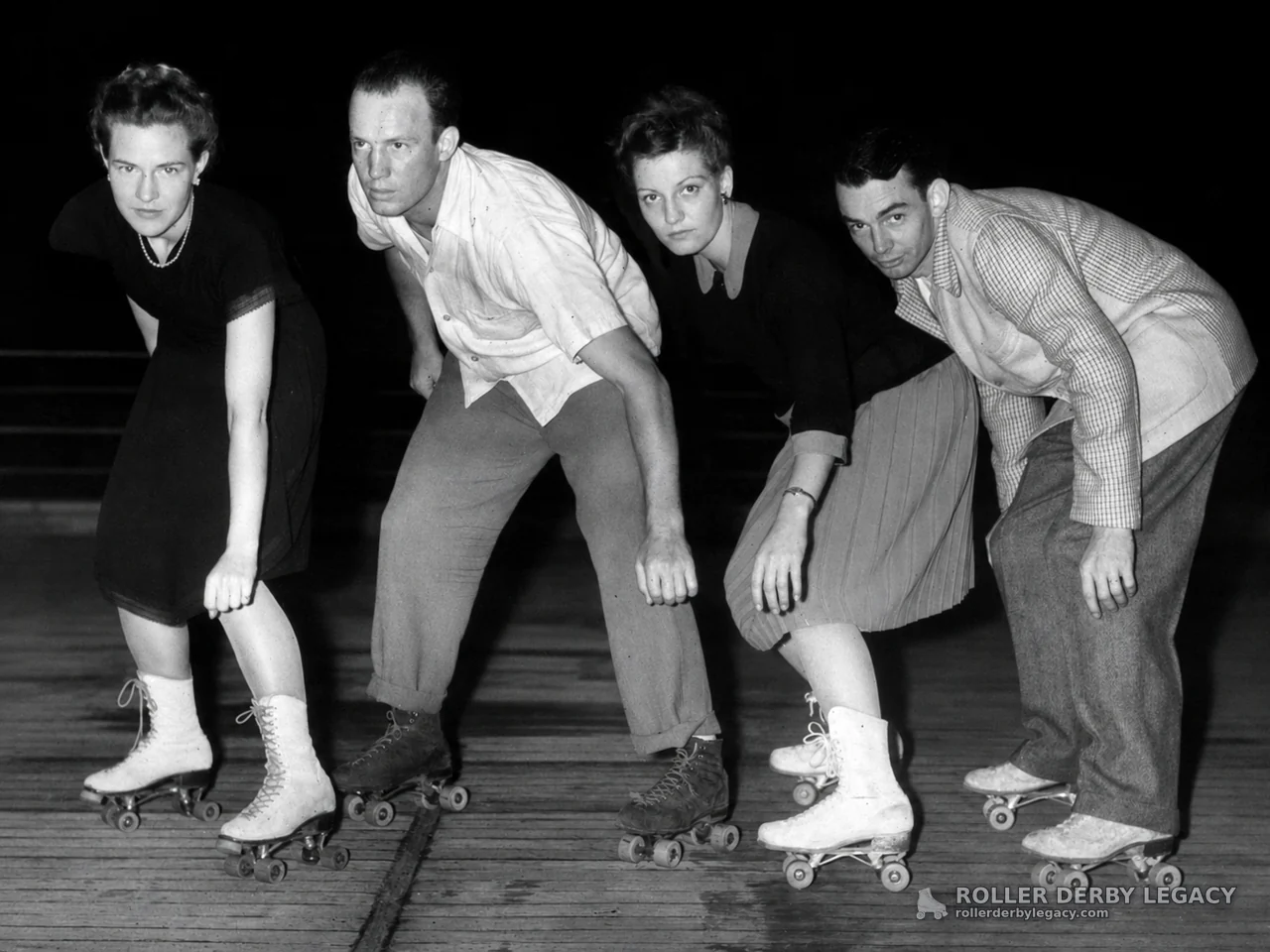 Four Roller Skaters Posed on a Wooden Rink