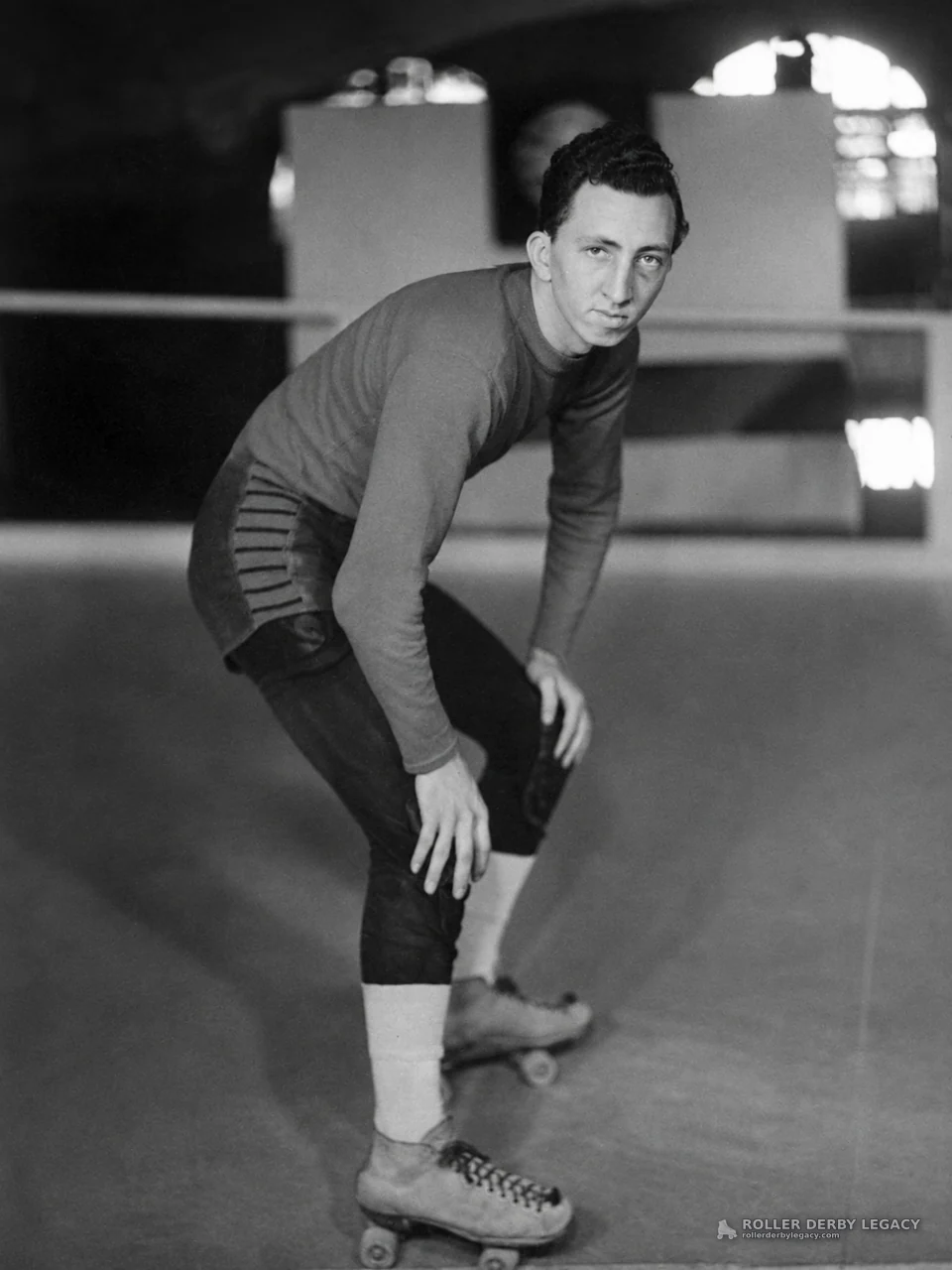 Skater in Low Stance at Indoor Rink
