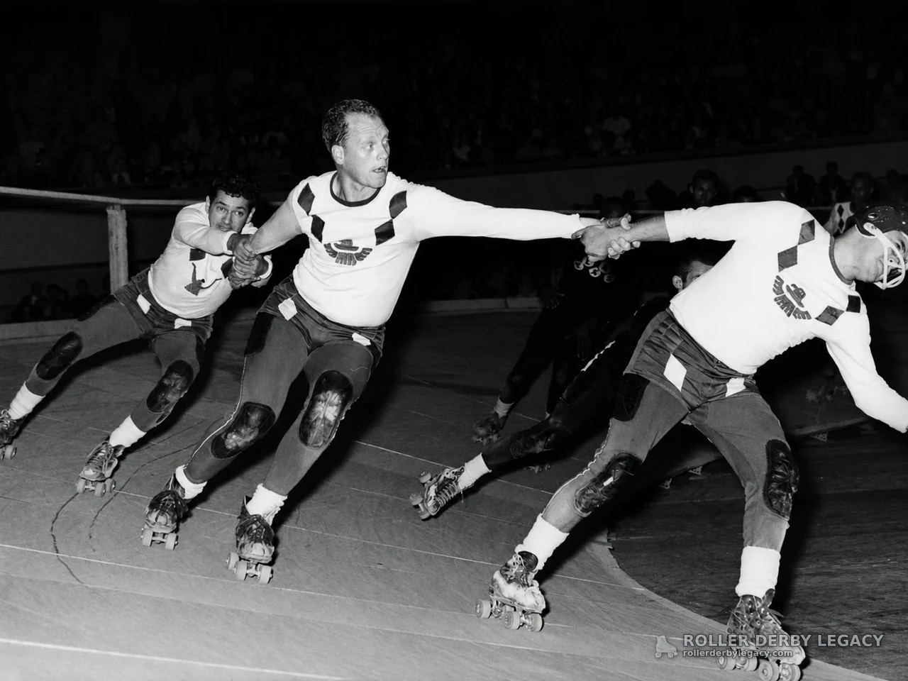 Skaters Linking Hands on a Banked Roller Derby Track