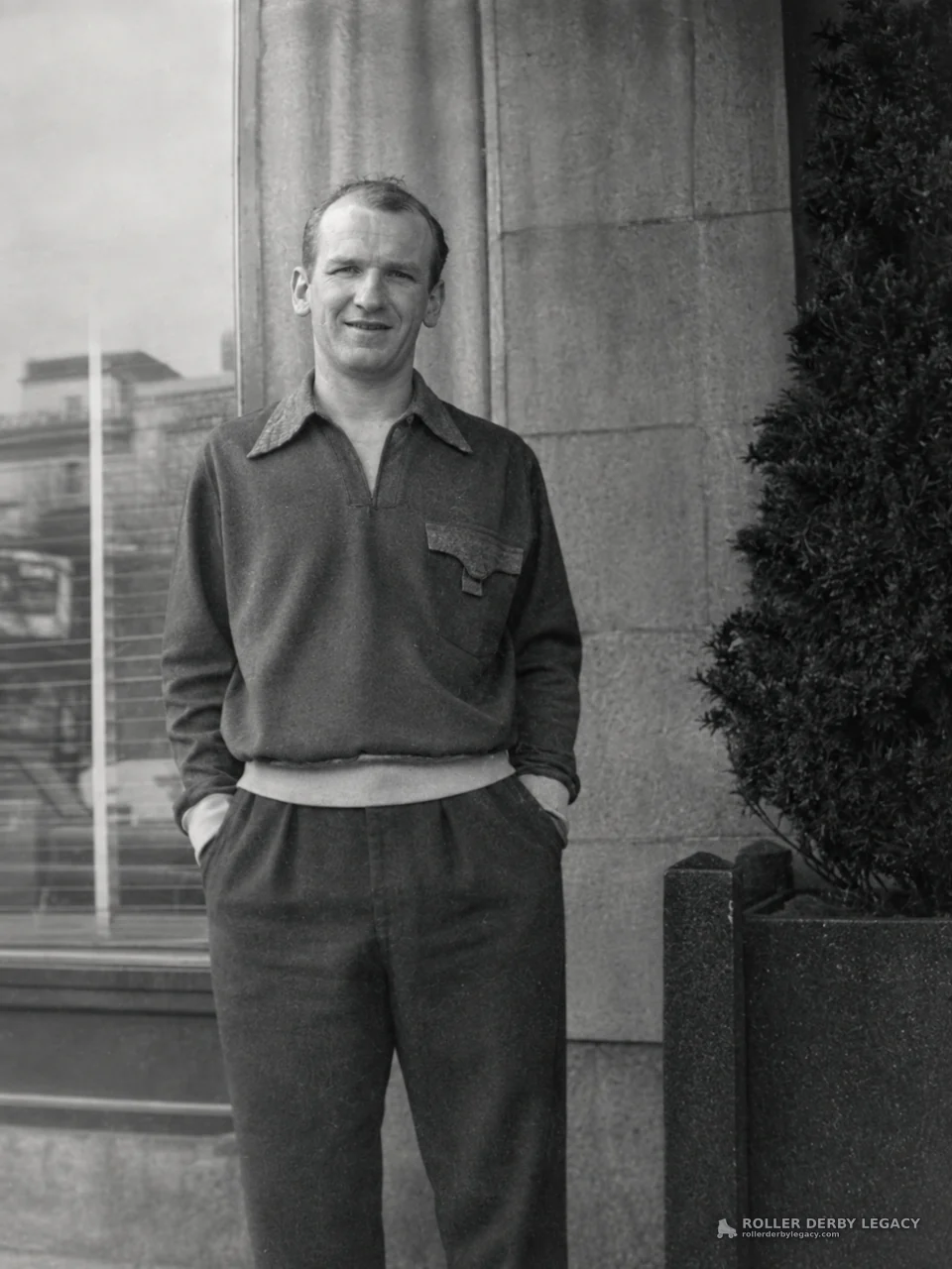 Man Outside a Building Beside a Planter