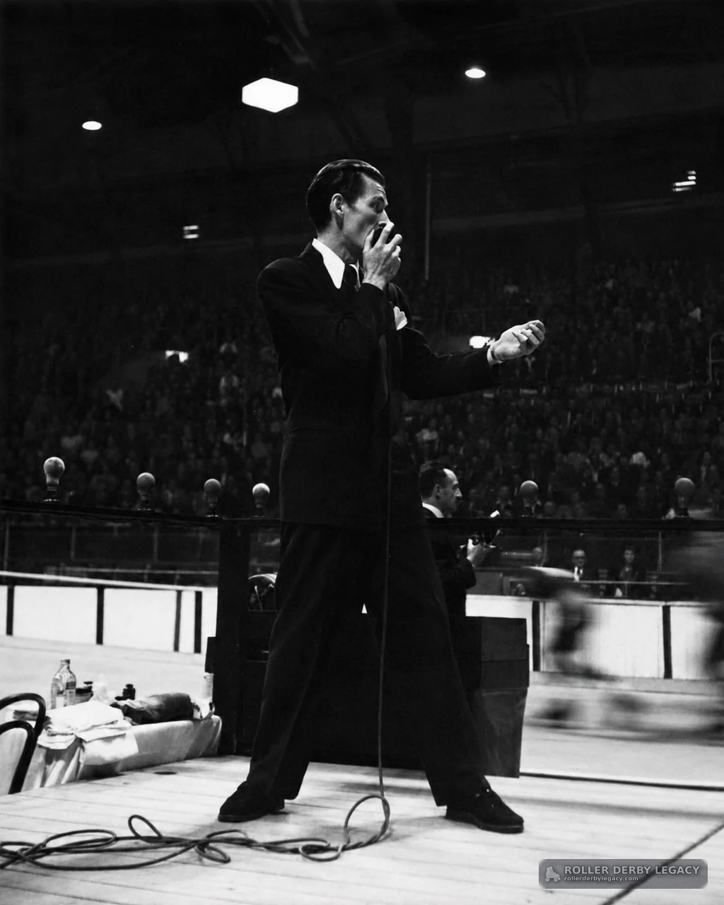 Suited Speaker Beside Indoor Track