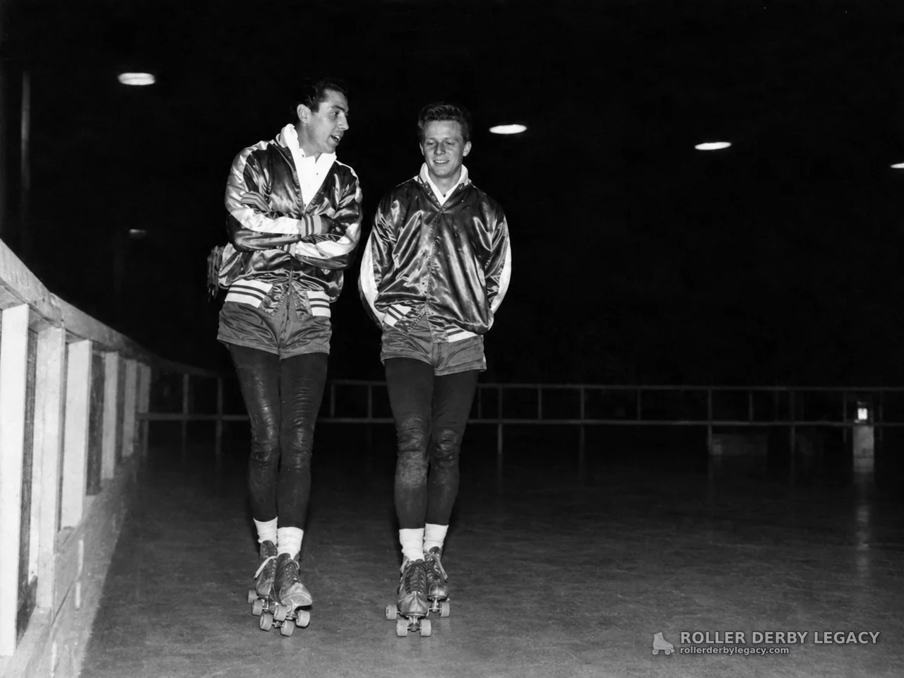 Two Skaters in Matching Jackets at an Indoor Rink