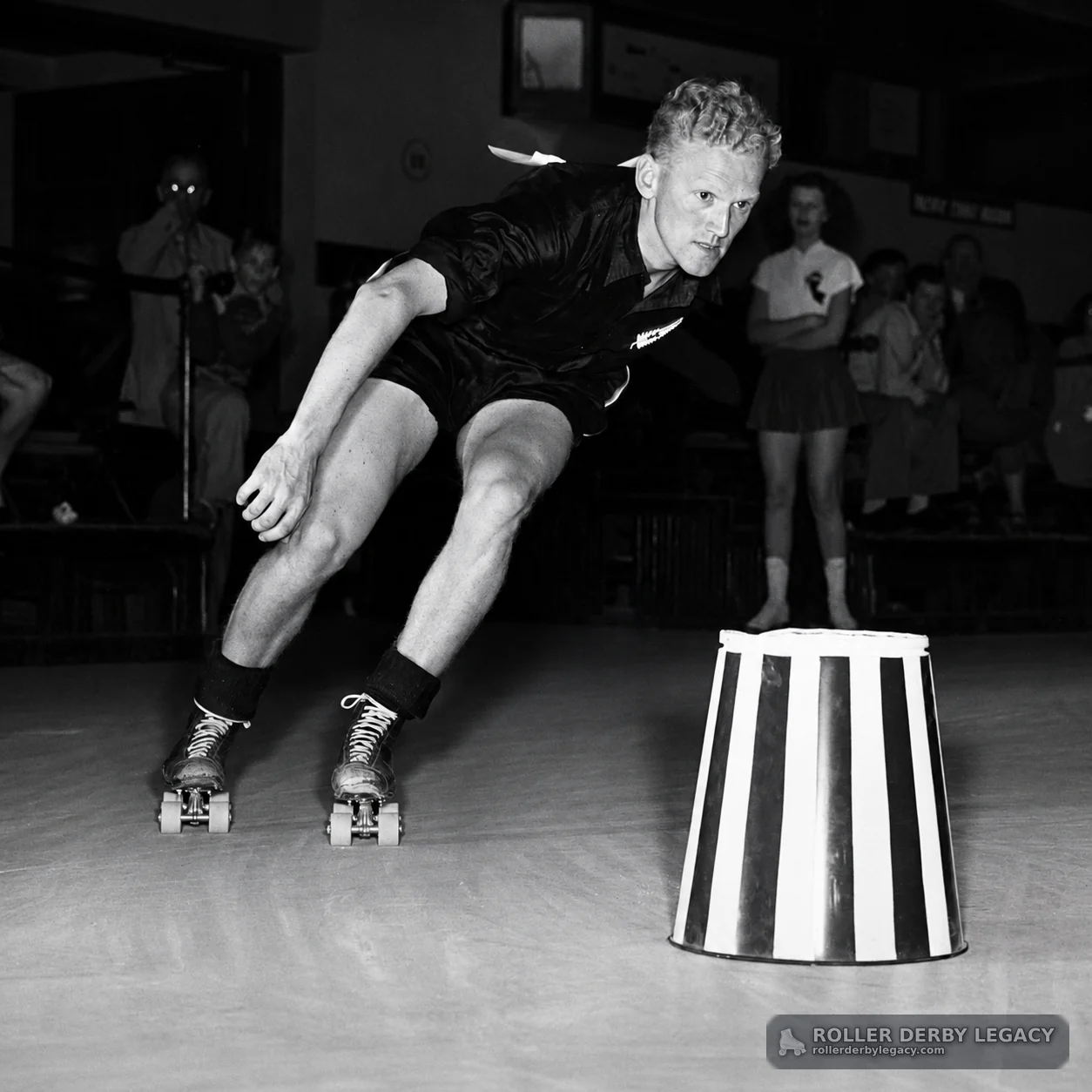 Skater Rounding a Striped Obstacle in an Indoor Rink