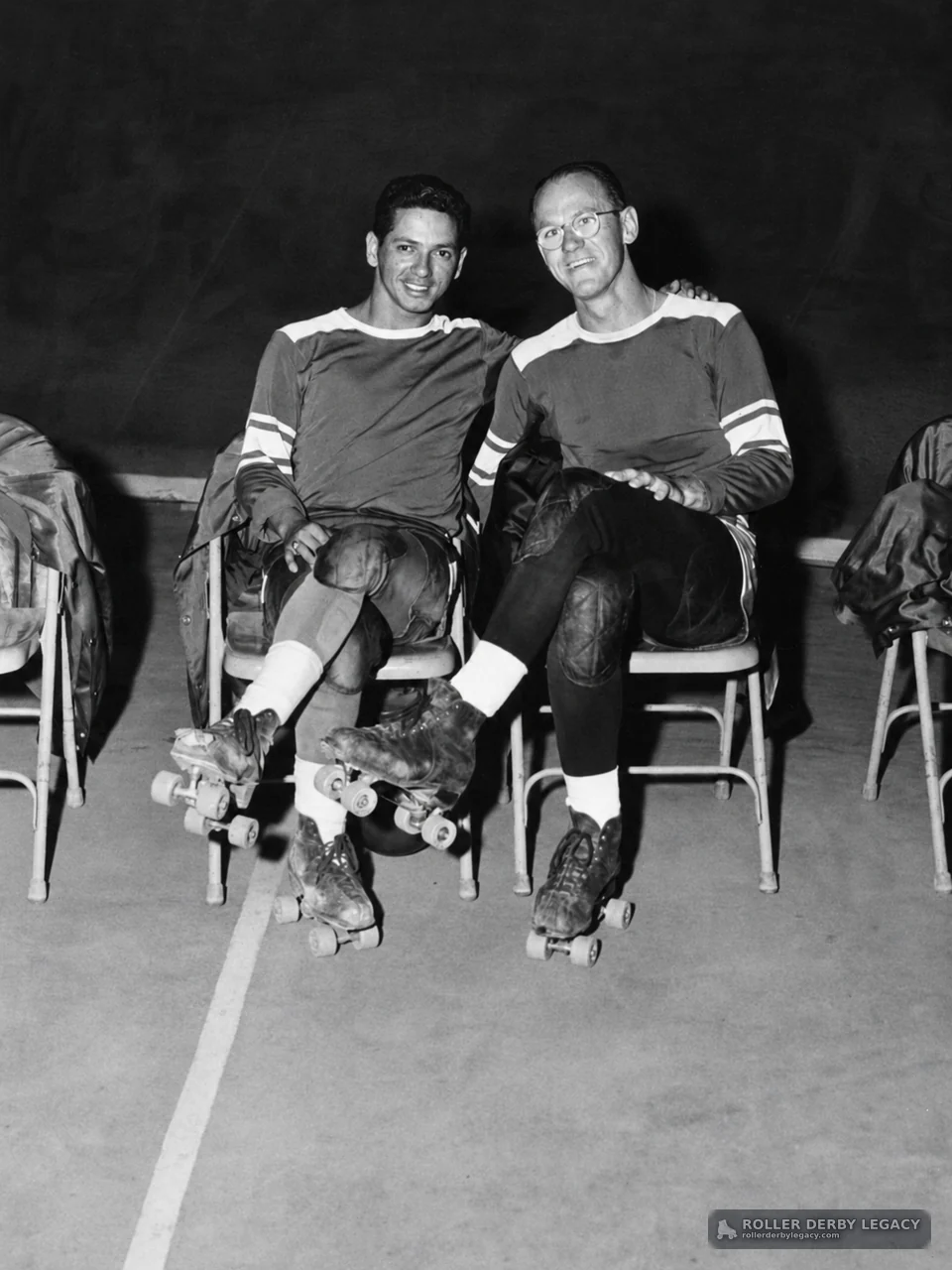 Two Seated Roller Skaters in Matching Uniforms