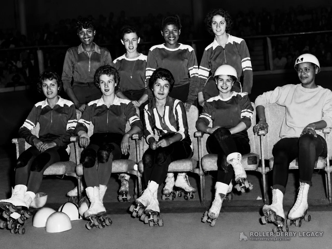 Nine Uniformed Roller Skaters in an Indoor Arena