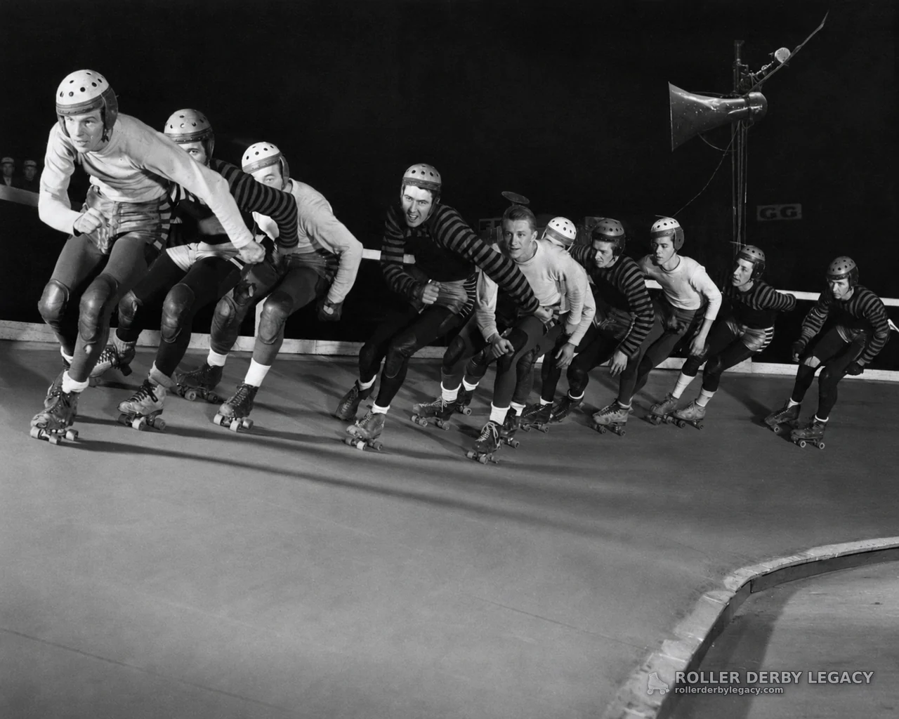 Helmeted Roller Derby Skaters Rounding a Banked Track
