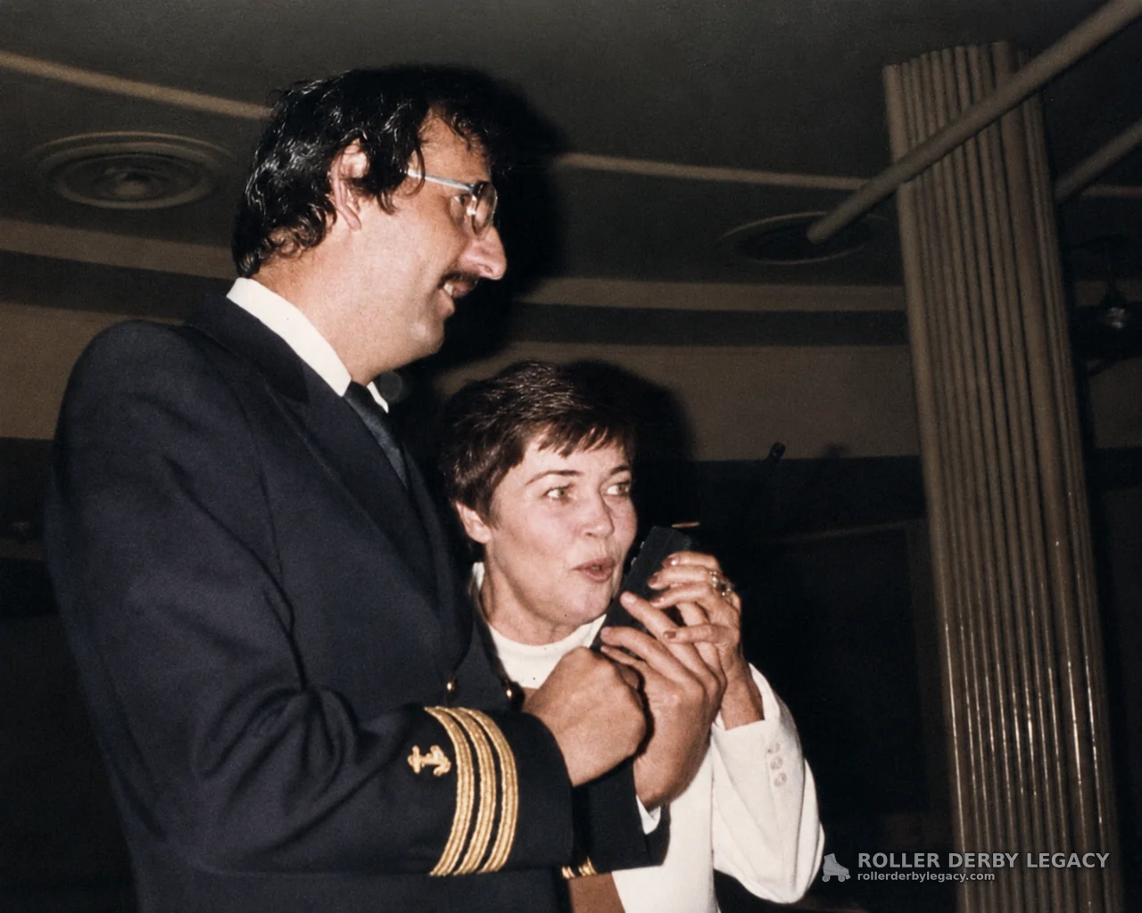 Two Adults with Handheld Device in an Indoor Room