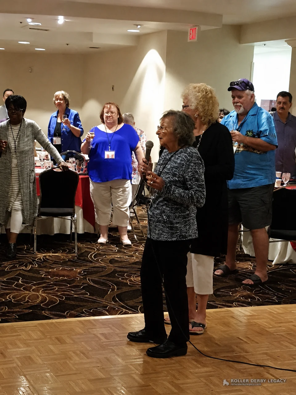 Woman Speaking with Microphone in Banquet Hall