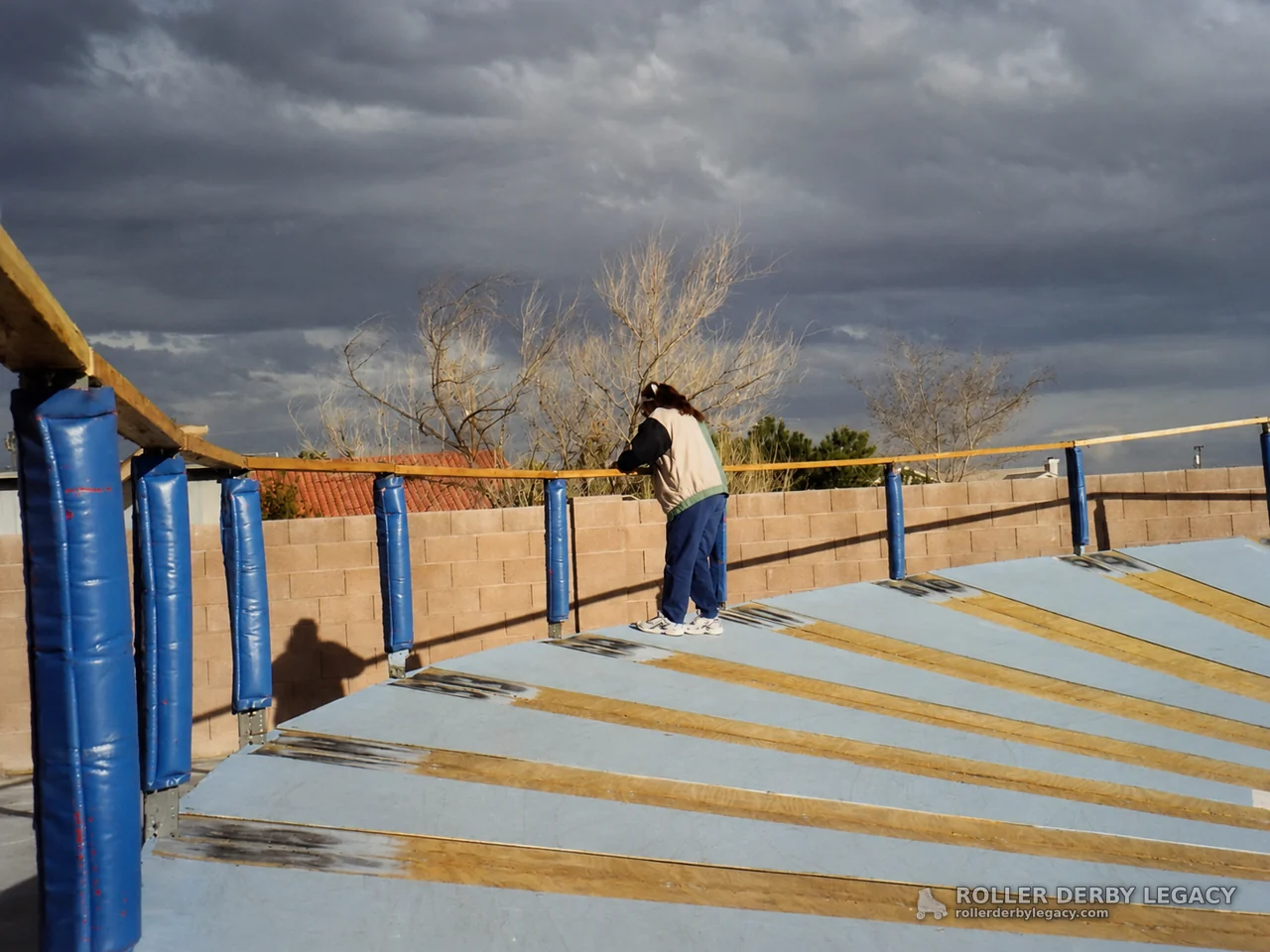 Person on Outdoor Banked Track Under Storm Clouds