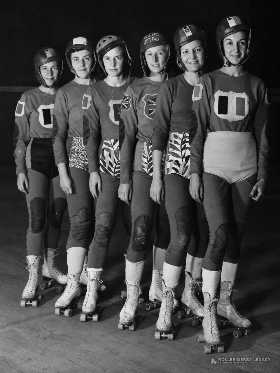 Six Helmeted Roller Derby Skaters in Indoor Rink Lineup