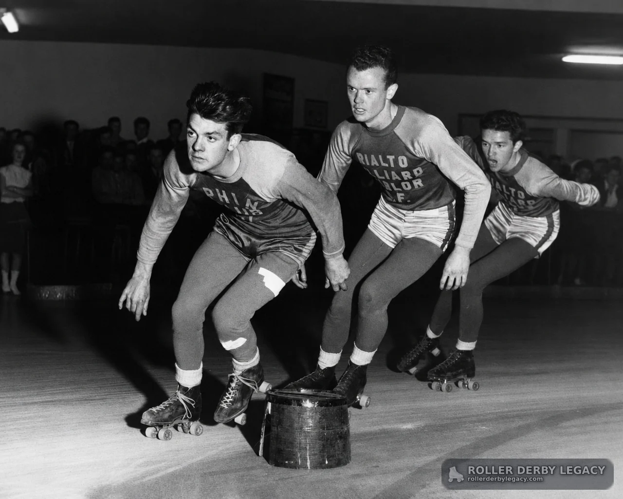 Three Skaters Passing an Indoor Rink Obstacle