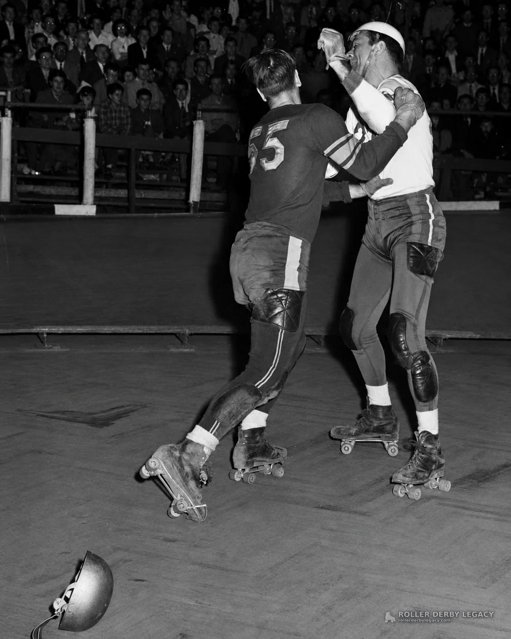 Number 55 skater in indoor roller derby contact