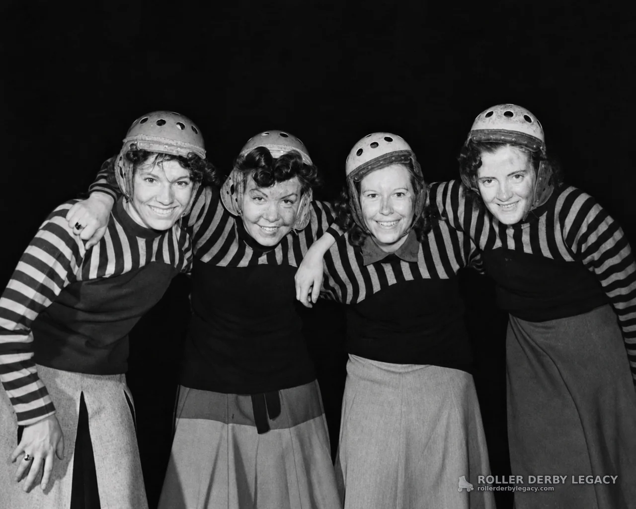Four Helmeted Women in Striped Roller Derby Uniforms