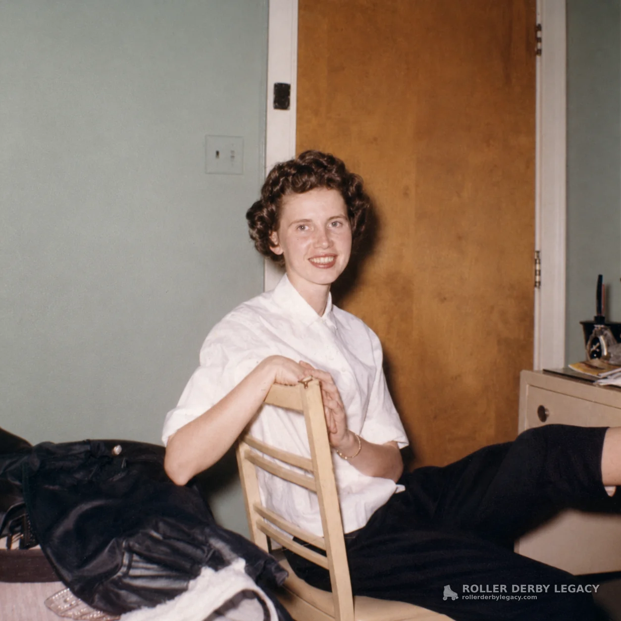 Smiling Woman Seated on a Wooden Chair Indoors