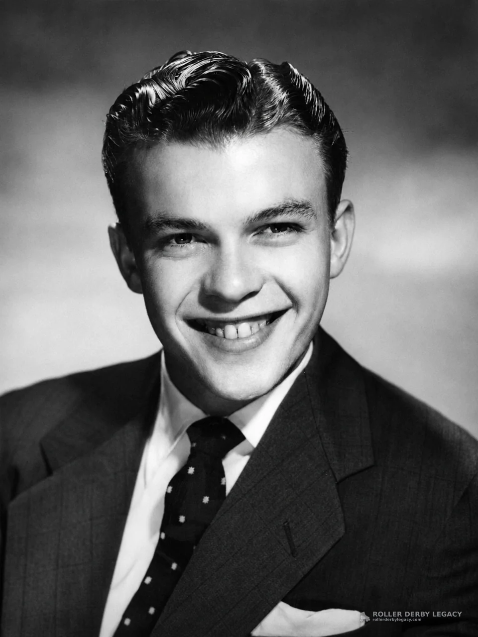Studio Portrait of a Smiling Young Man in a Suit