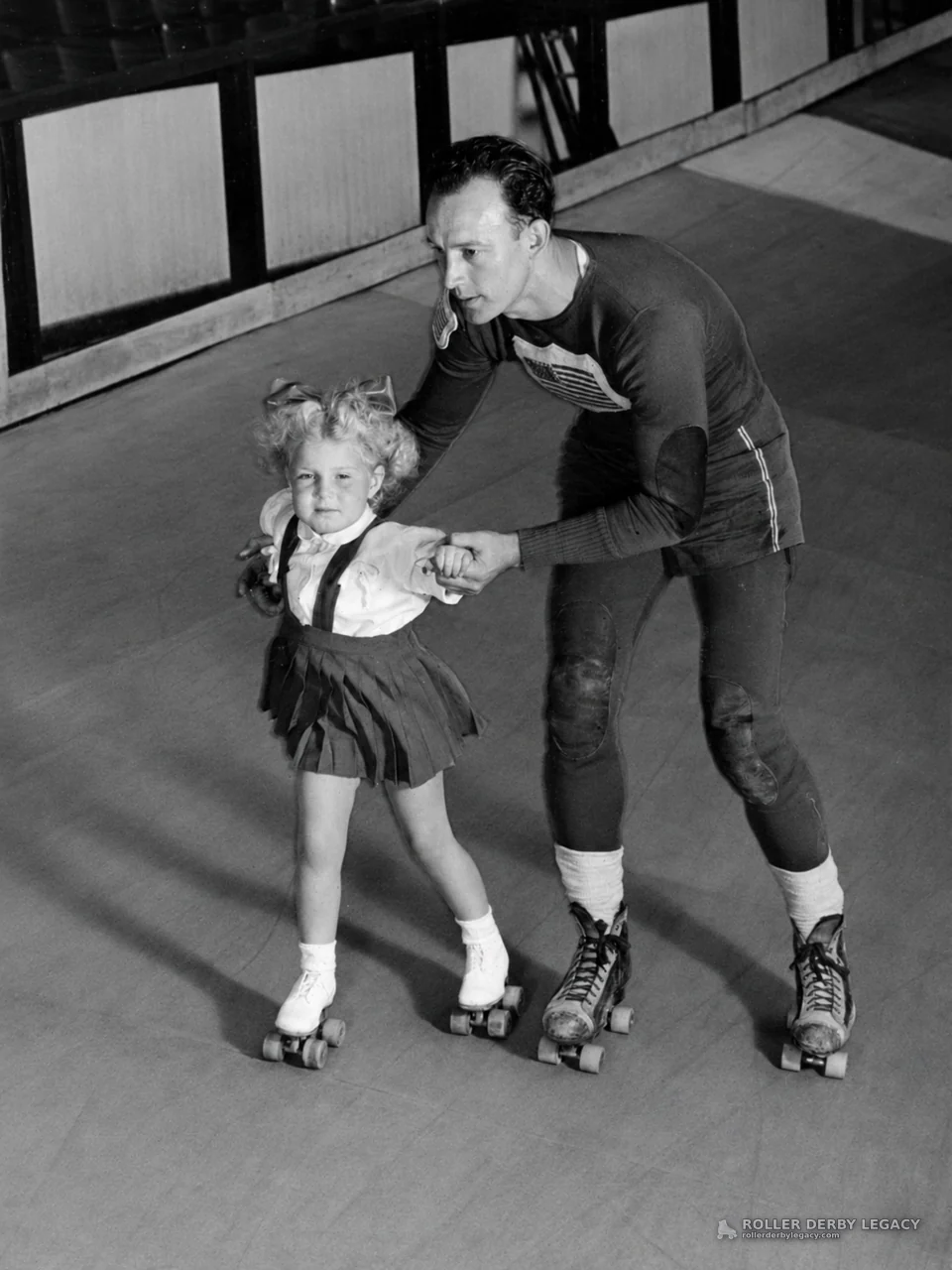 Adult skater helps a child on quad roller skates