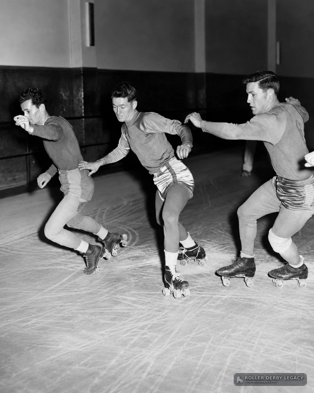 Three Skaters in Close Formation on an Indoor Rink