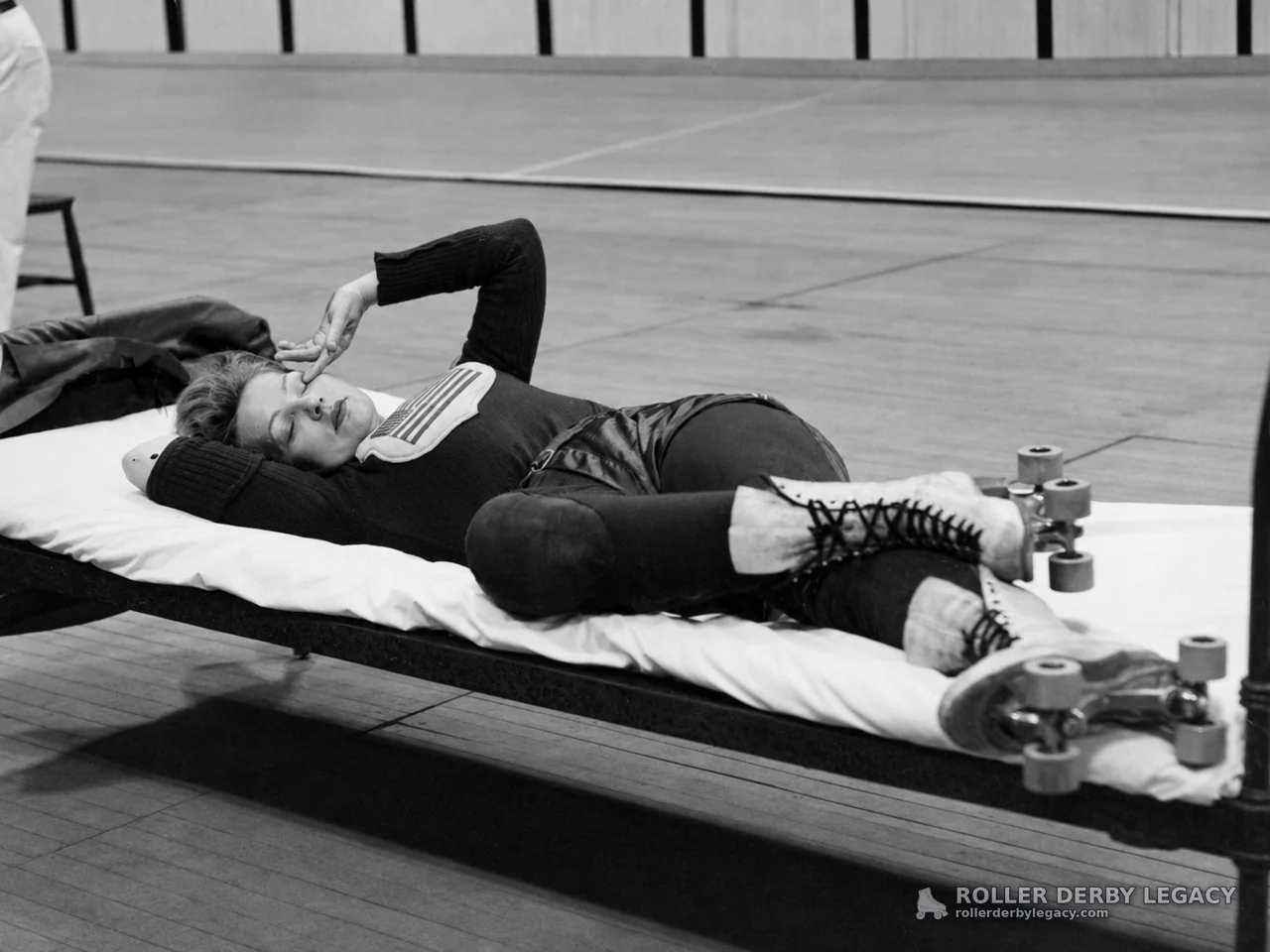 Skater Resting on Cot Beside Indoor Rink