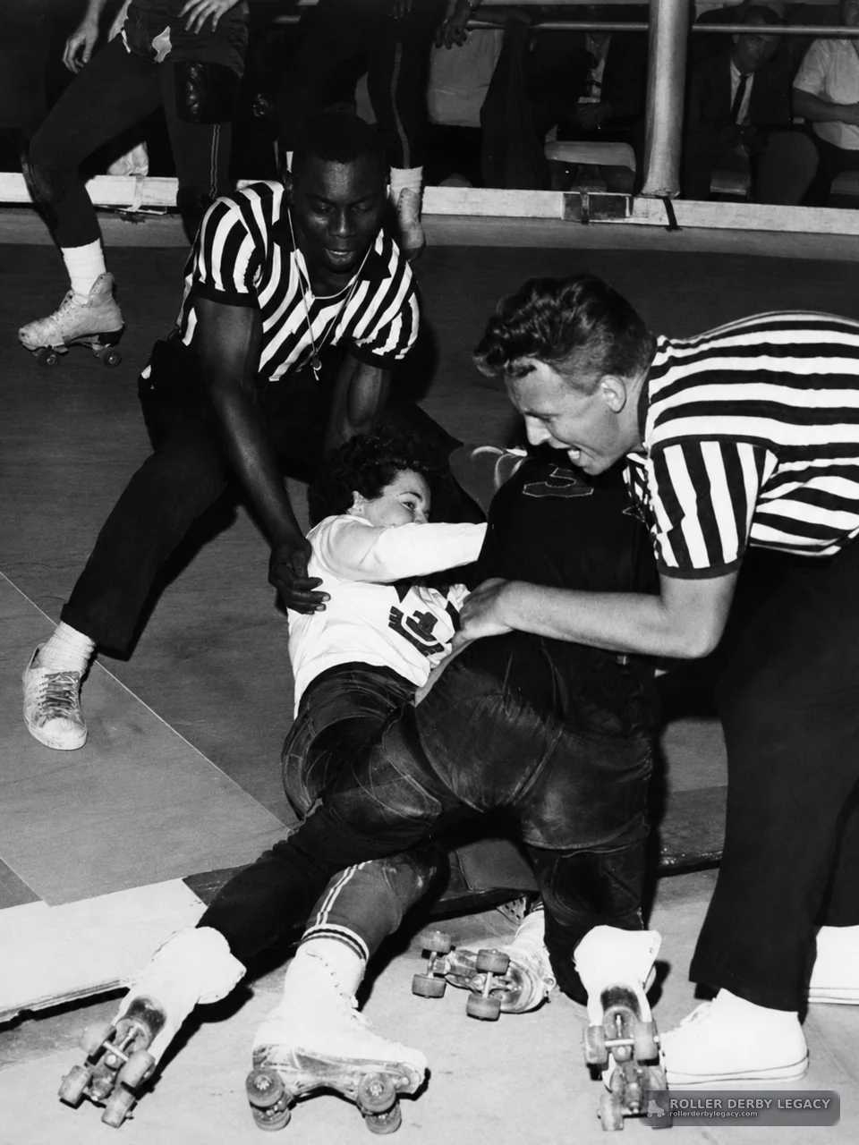Referees Aid Tangled Roller Derby Skaters on the Rink