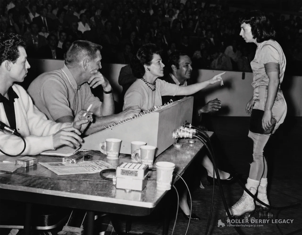 Skater at Officials' Table in an Indoor Arena