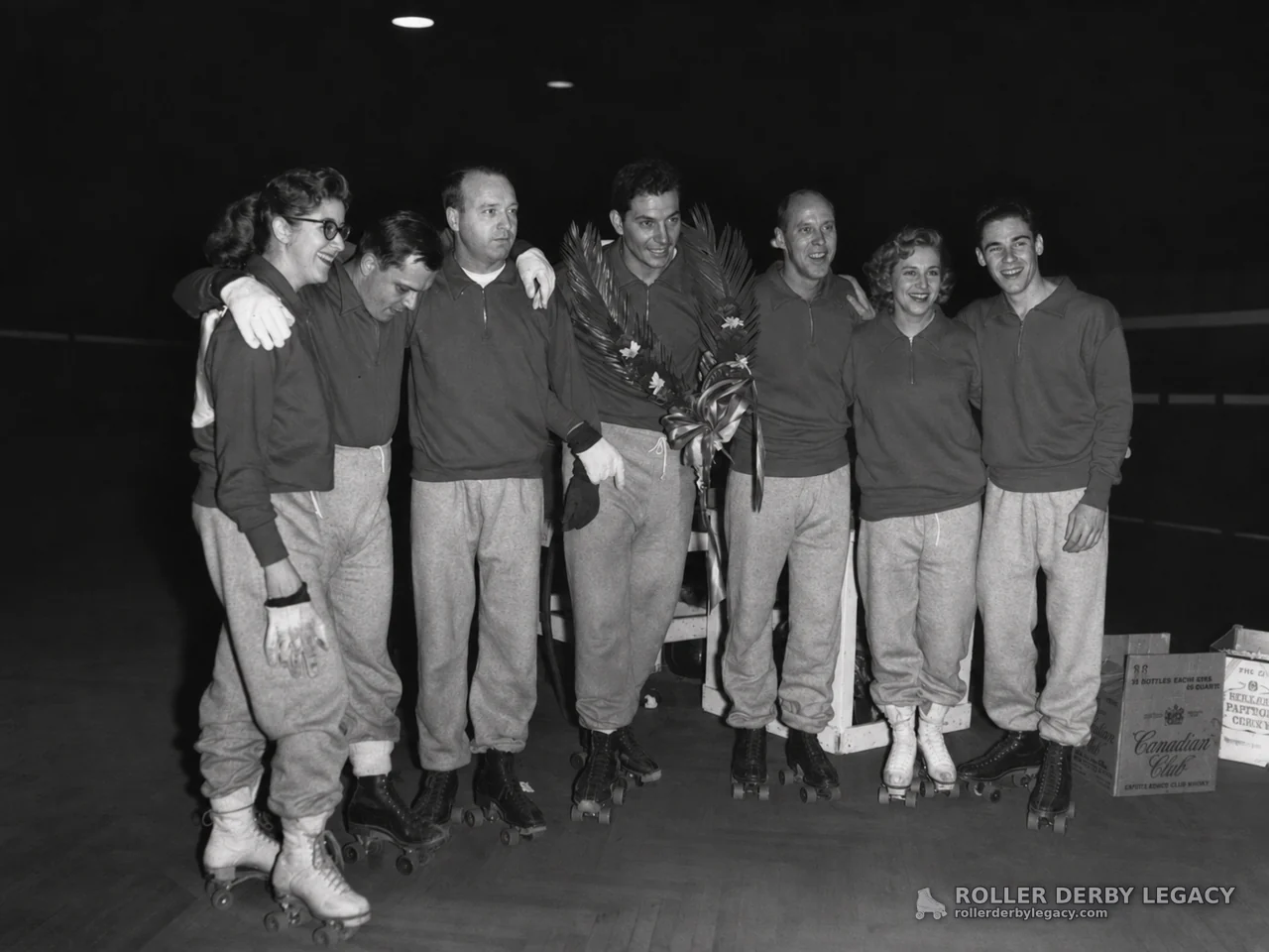 Roller Skaters Posing with Floral Arrangement on Indoor Rink