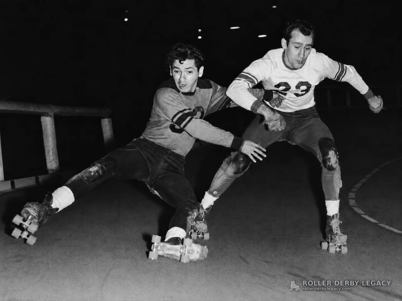 Two Roller Skaters Racing Through an Indoor Turn