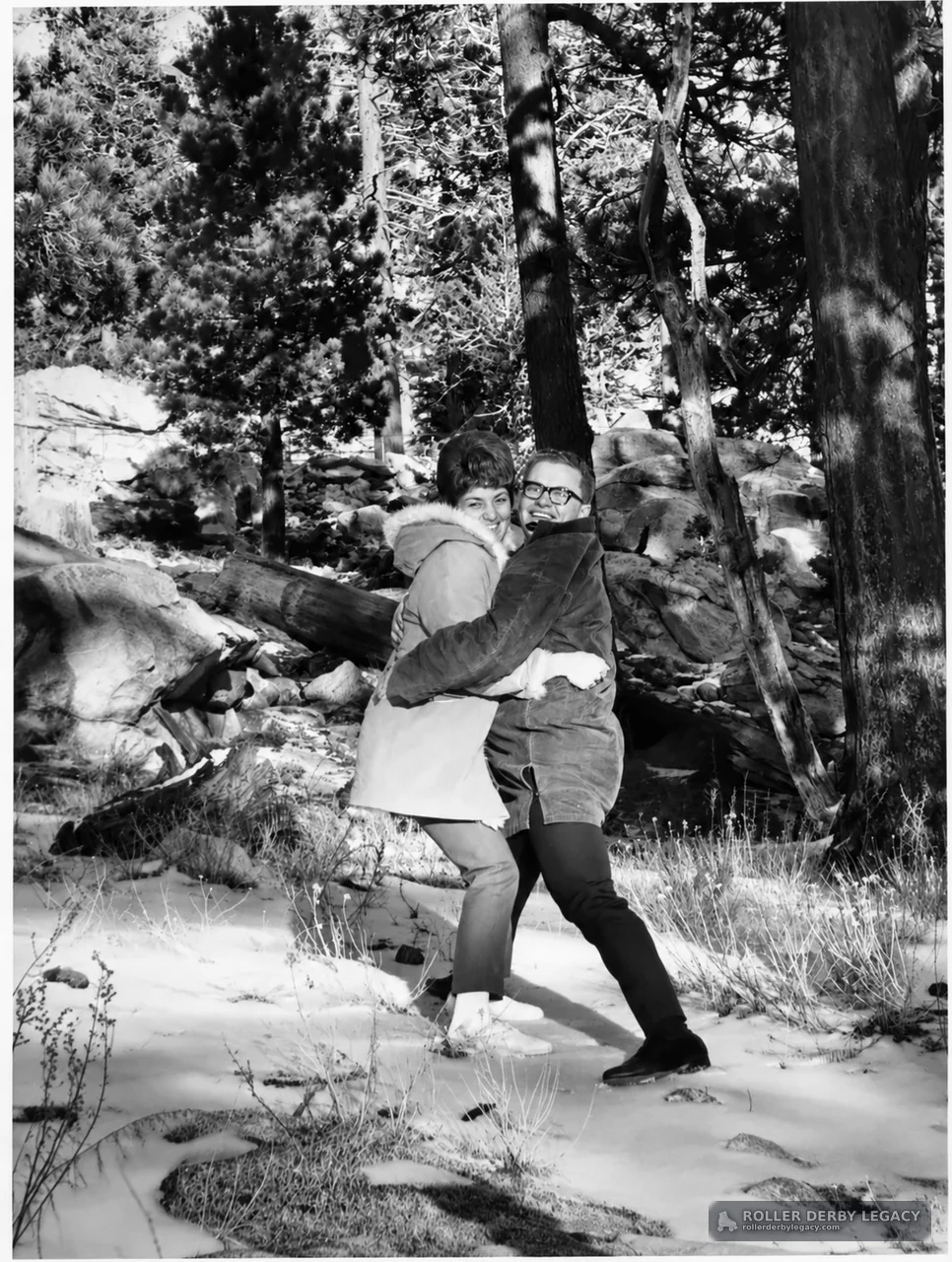 Two People Embracing in a Snowy Wooded Area