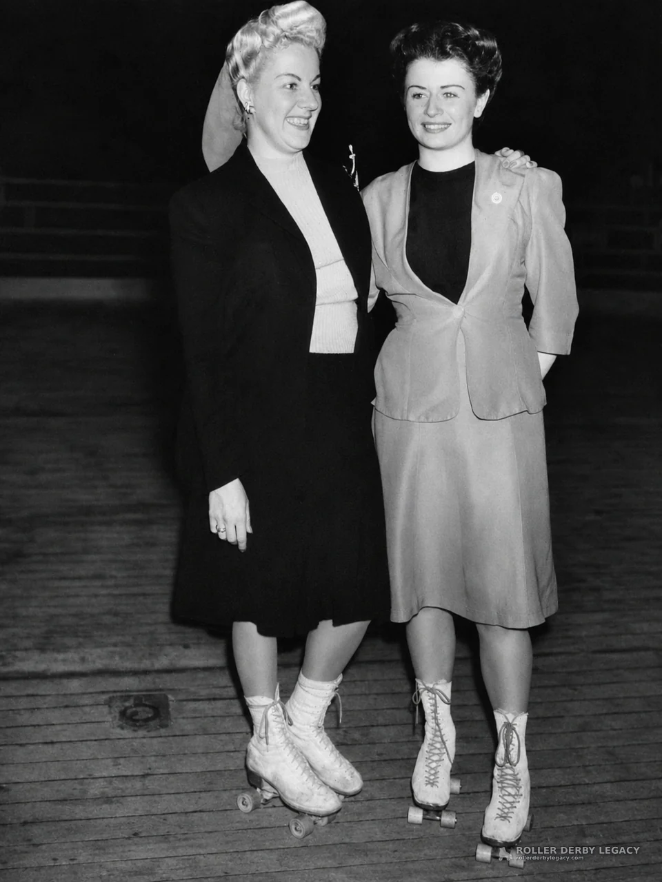 Two Women on Quad Skates at an Indoor Rink