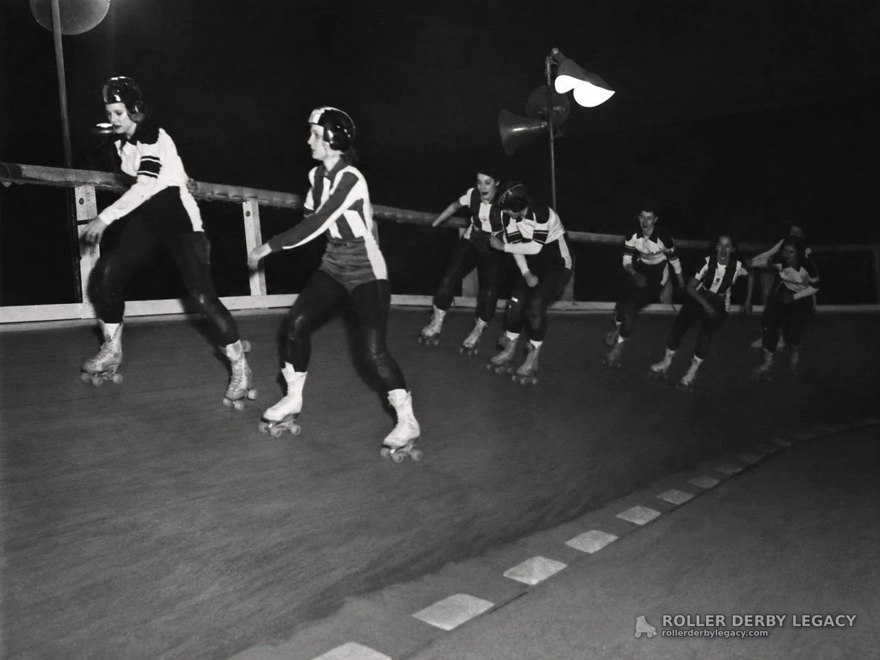 Helmeted Skaters on a Banked Roller Derby Track