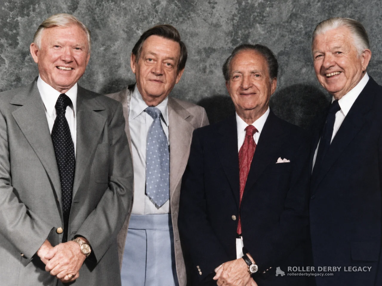 Four Men in Suits Against a Studio Backdrop