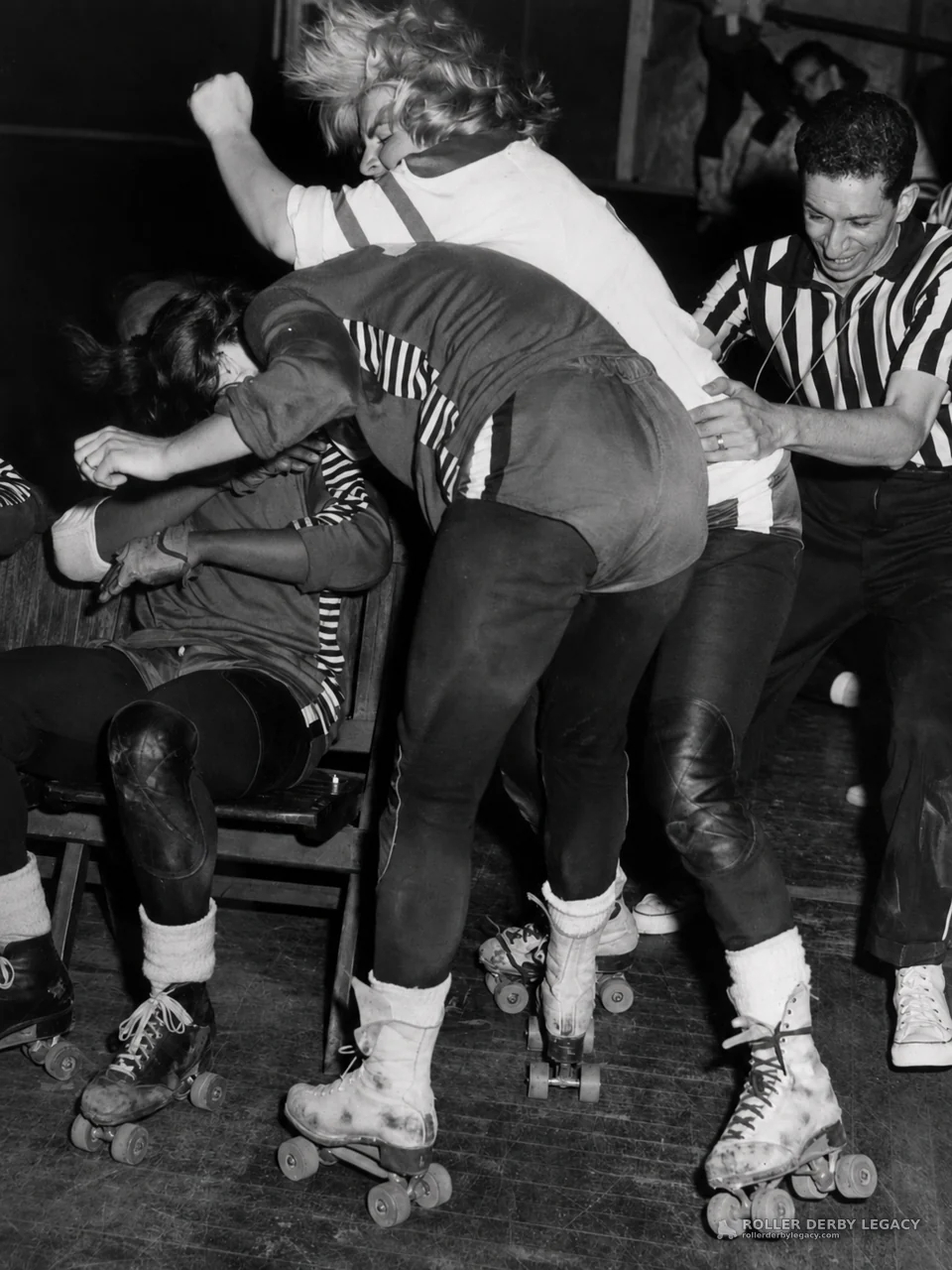 Roller Derby Skaters Grapple as Referee Intervenes