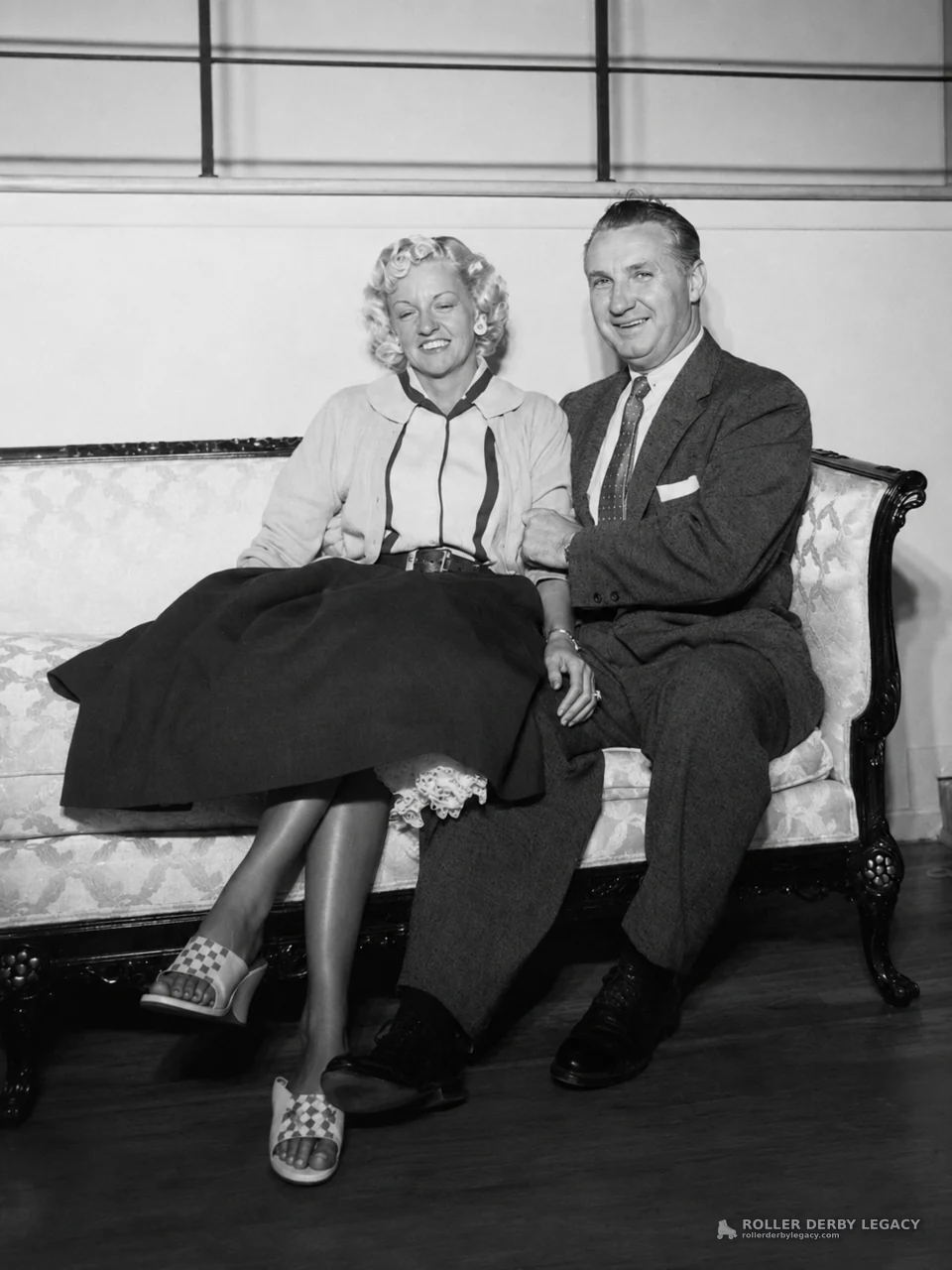 Smiling Couple Seated on Ornate Sofa
