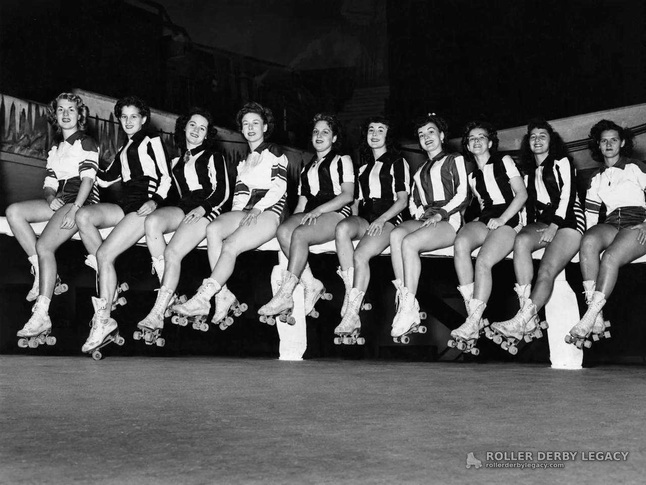 Women Skaters in Striped Uniforms Seated at an Indoor Rink