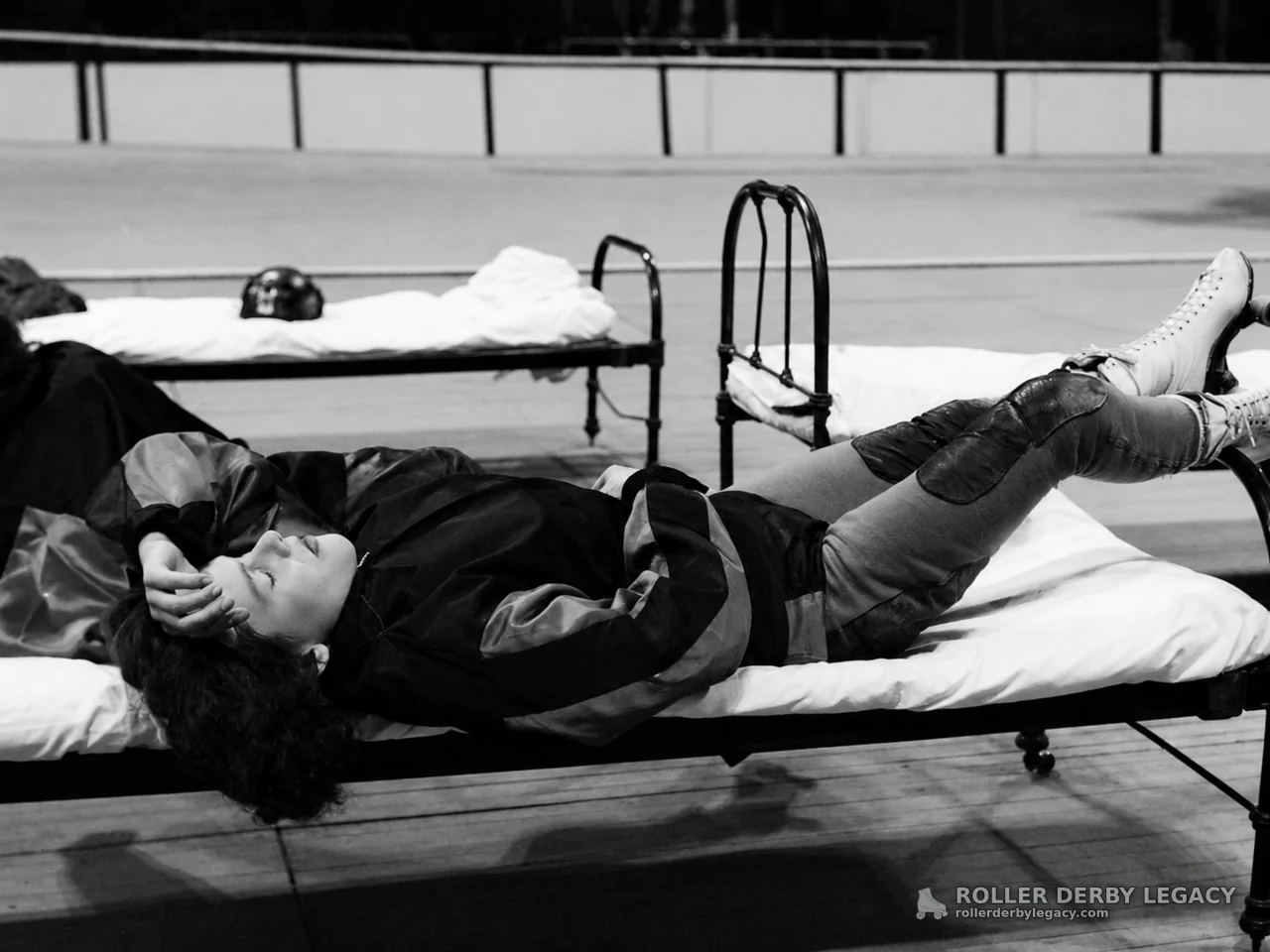 Skater Resting on Cot Beside Indoor Rink