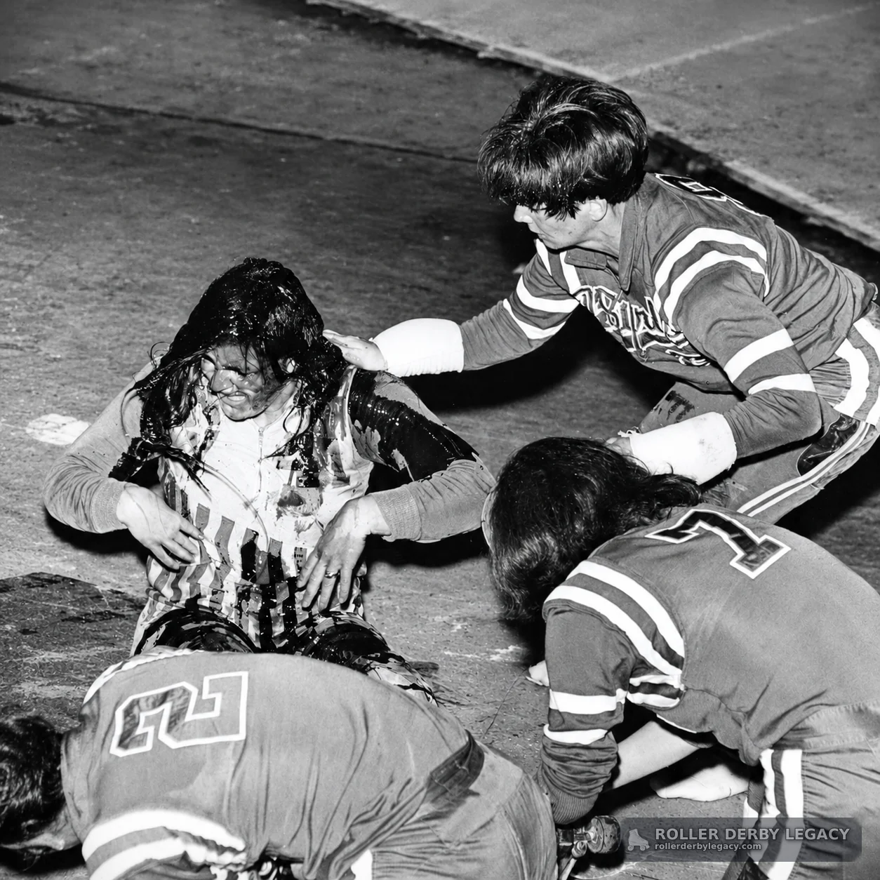 Skaters Gather Around Seated Figure on Roller Derby Track