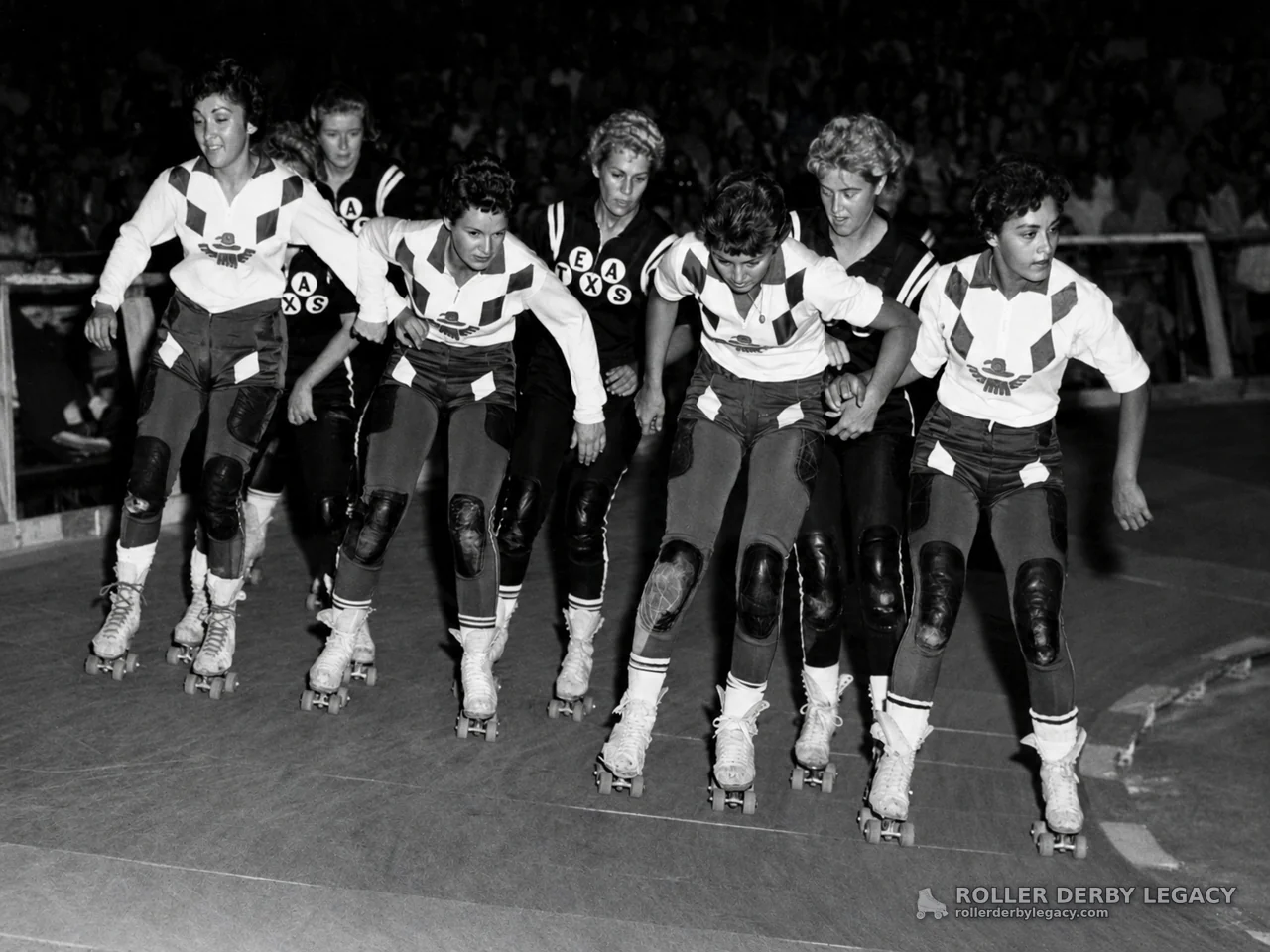 Roller Derby Skaters in a Tight Pack on an Indoor Track