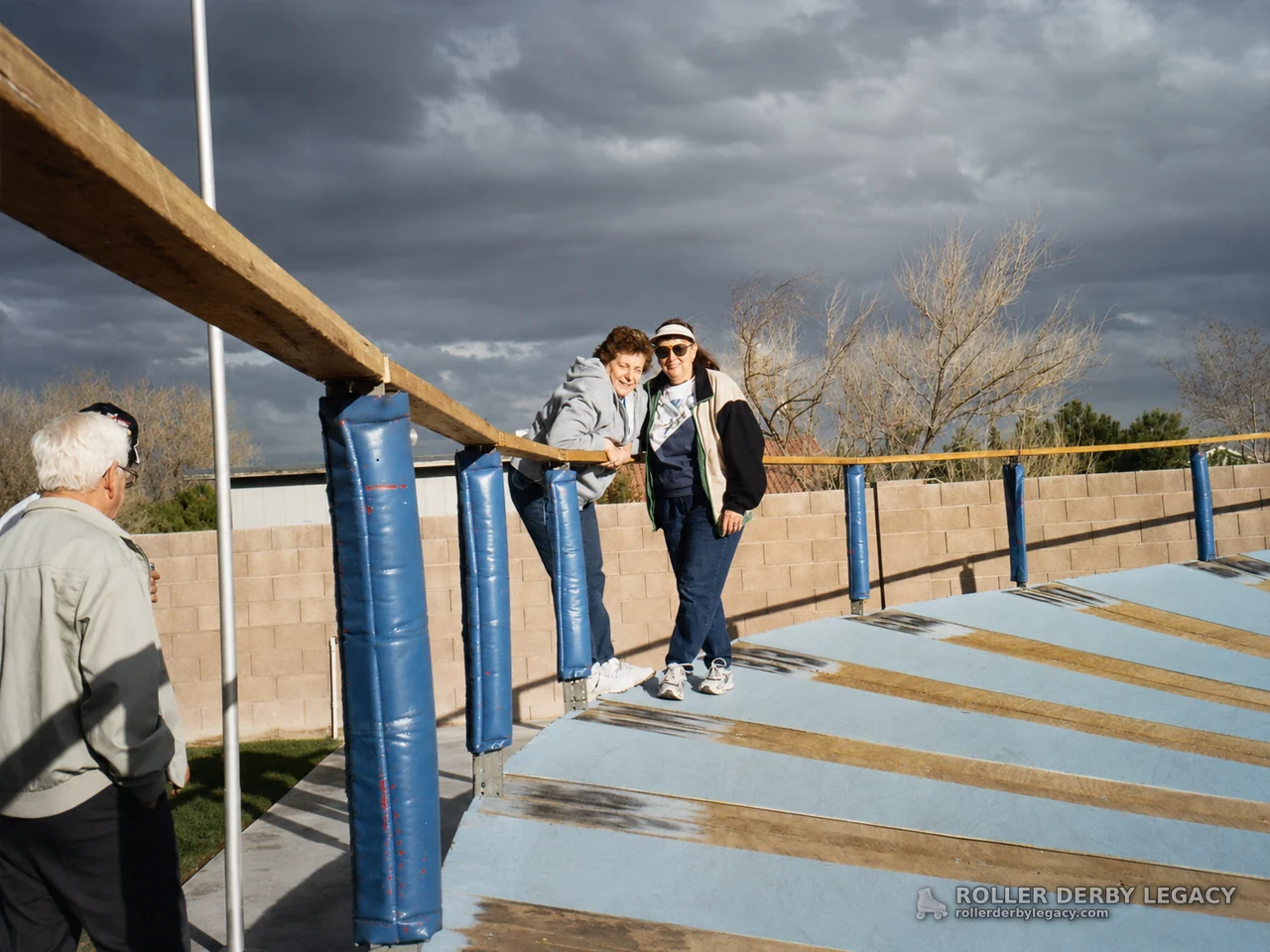 Group Portrait Beside an Outdoor Blue Banked Track