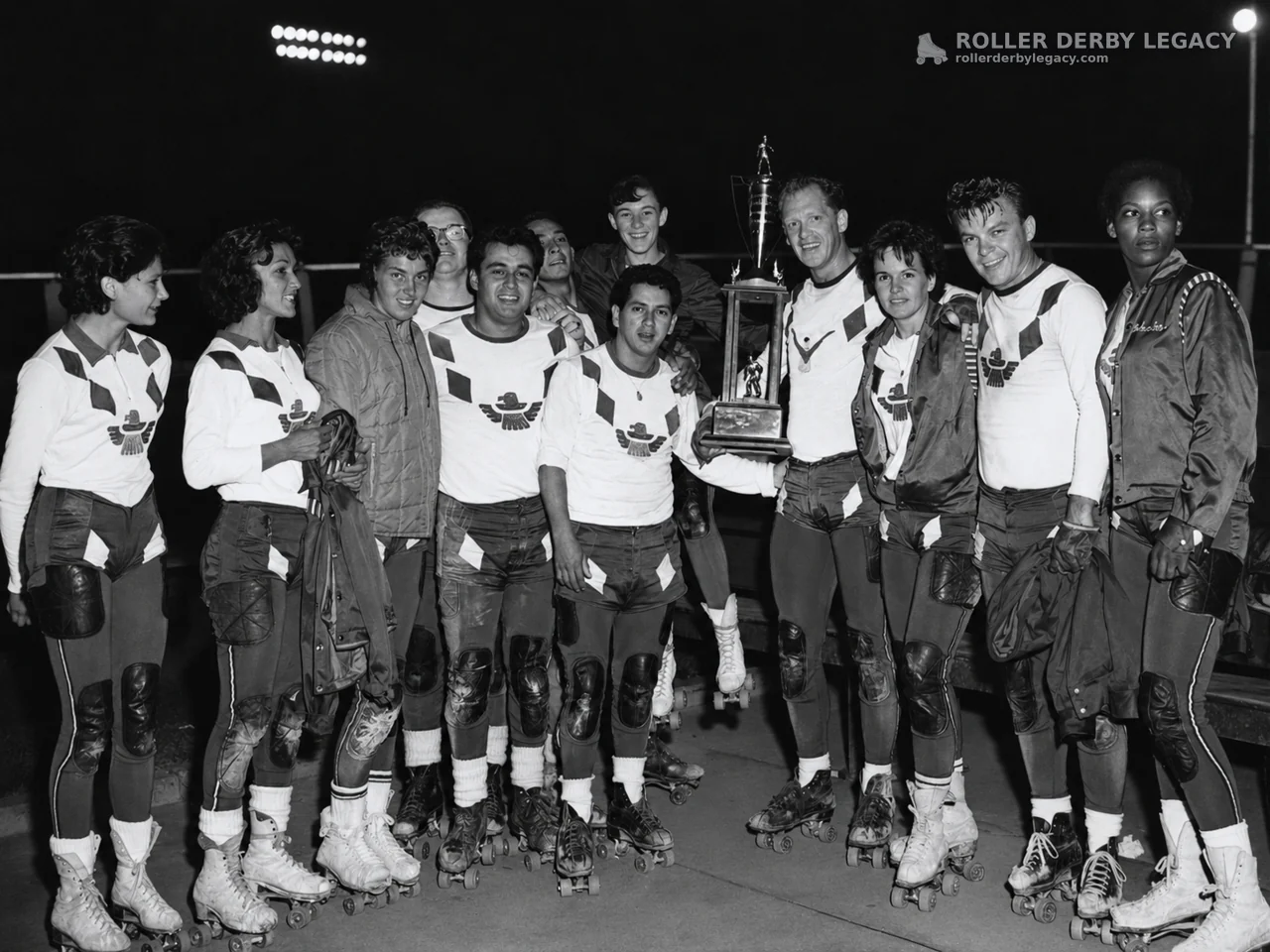Thunderbirds Skaters Posing with Trophy Under Stadium Lights