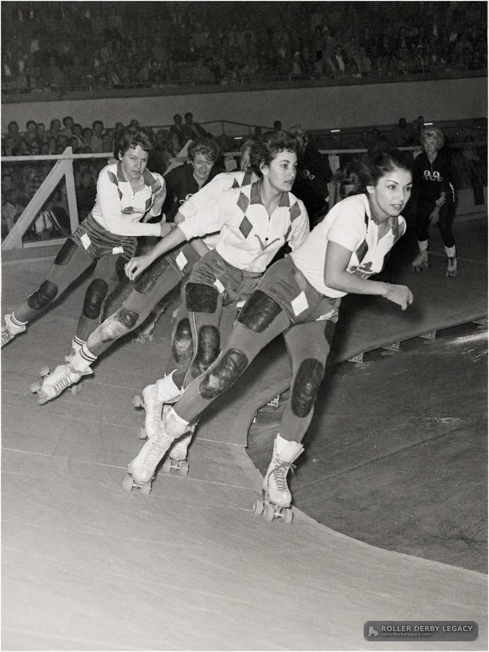 Roller Derby Skaters Rounding a Banked Track Turn