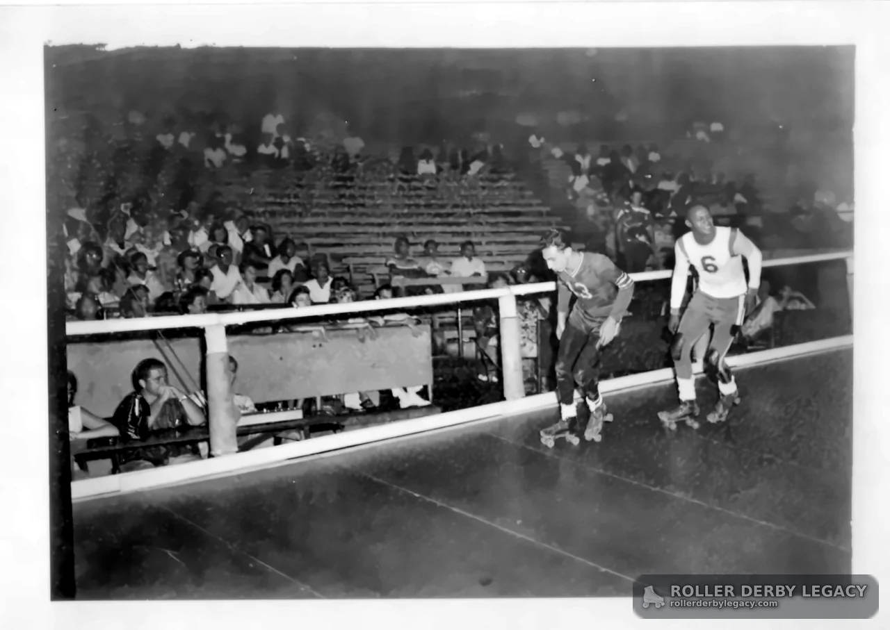 Two Roller Derby Skaters Passing the Rail
